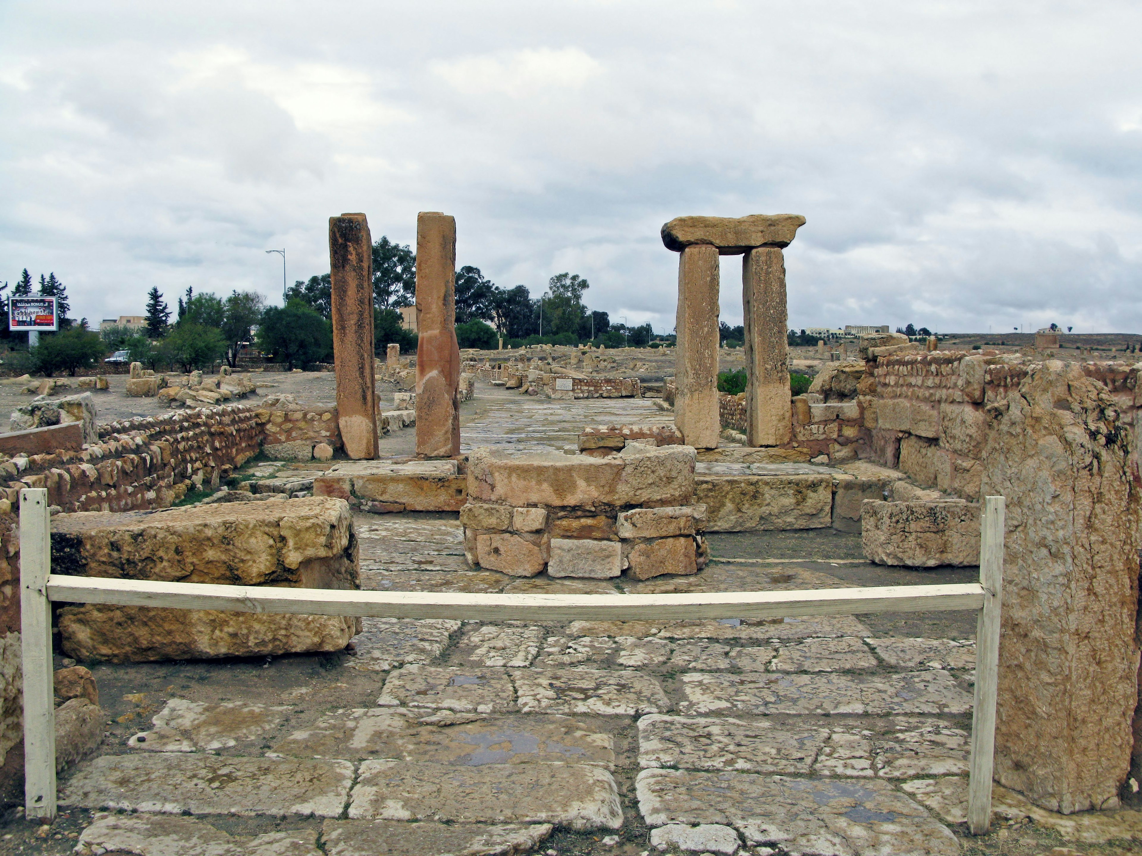 Paysage de ruines anciennes avec des piliers en pierre et une structure circulaire