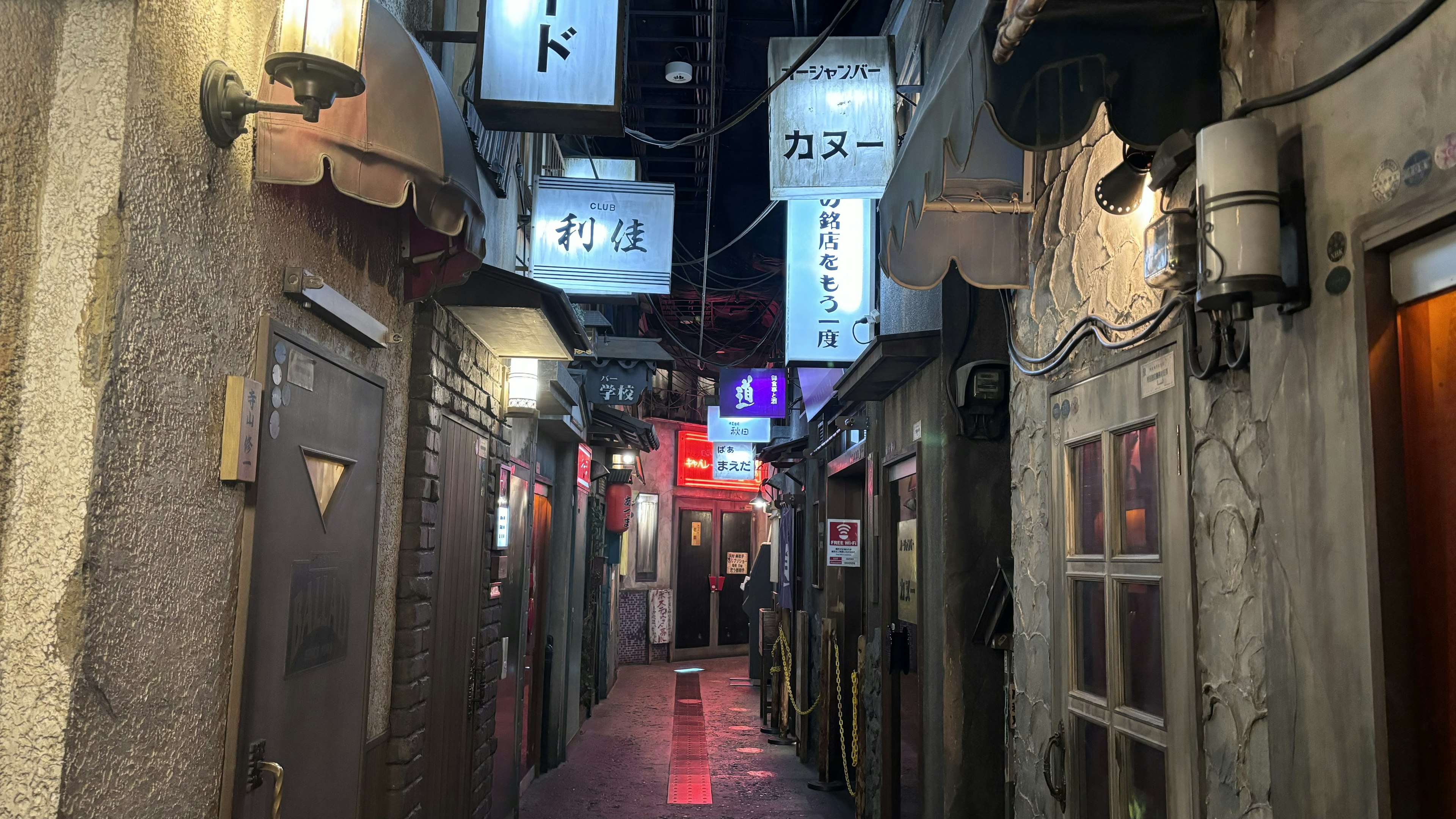 Narrow alleyway lined with restaurant signs and doors