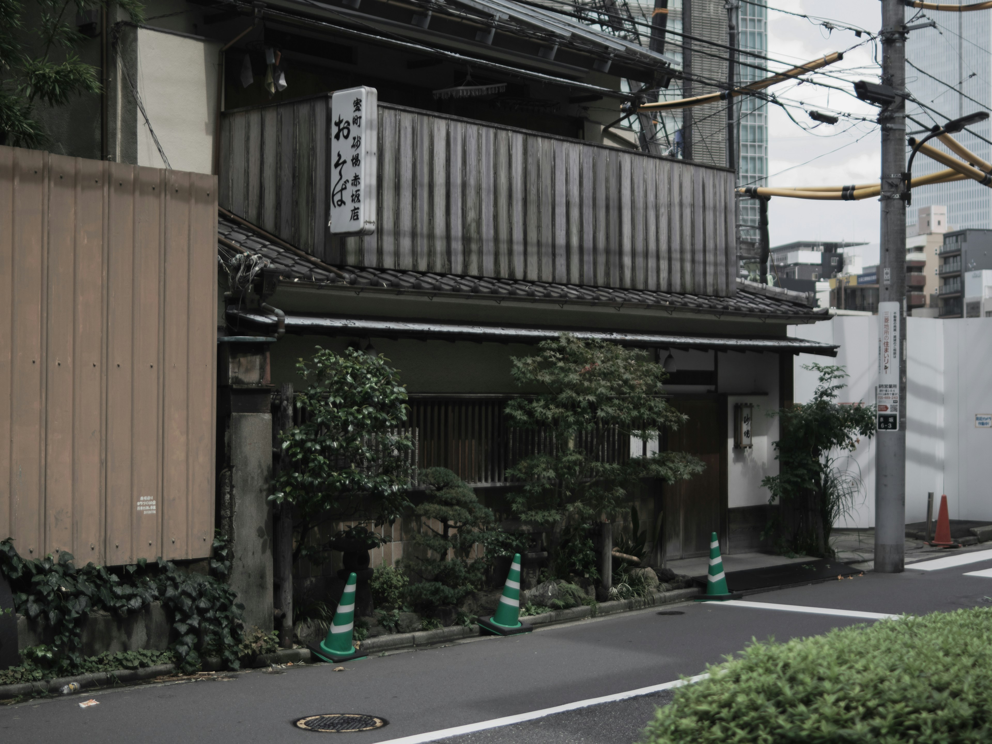 Traditionelles japanisches Gebäude mit Grünflächen in städtischer Umgebung