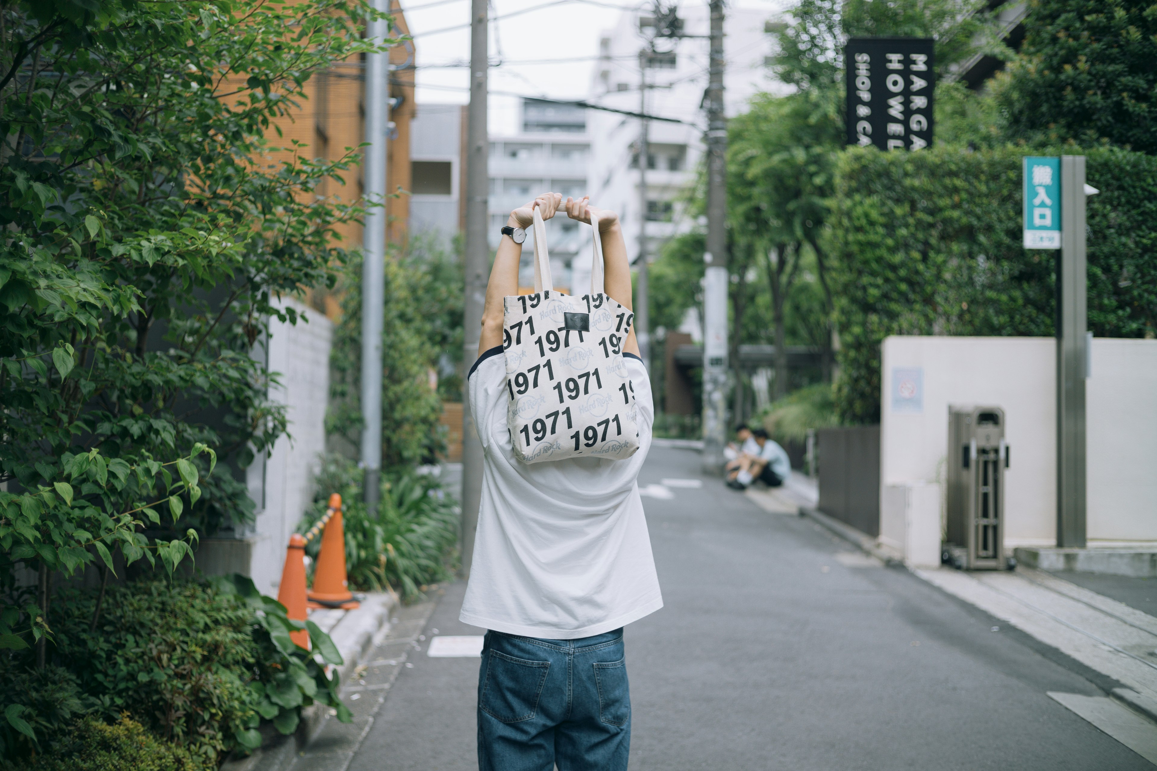 背中に1971と印刷されたTシャツを着た男性が街中を歩いている