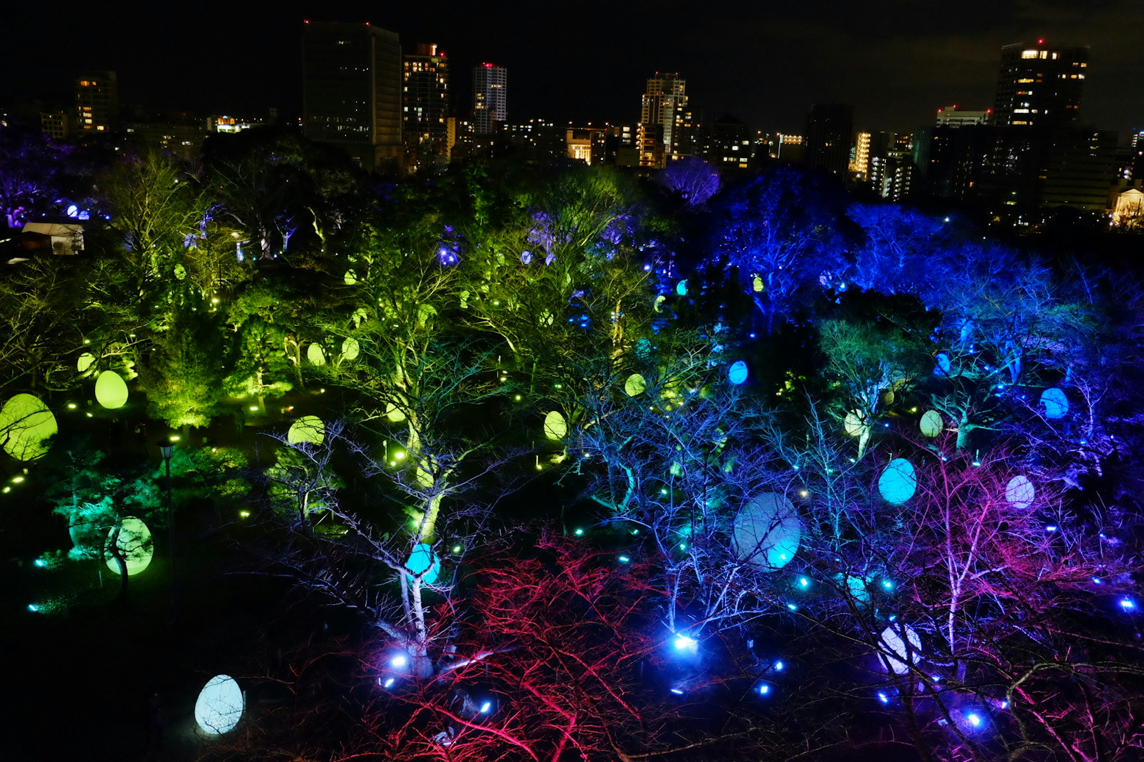 Ornements en forme d'œufs colorés illuminant des arbres dans un paysage urbain nocturne