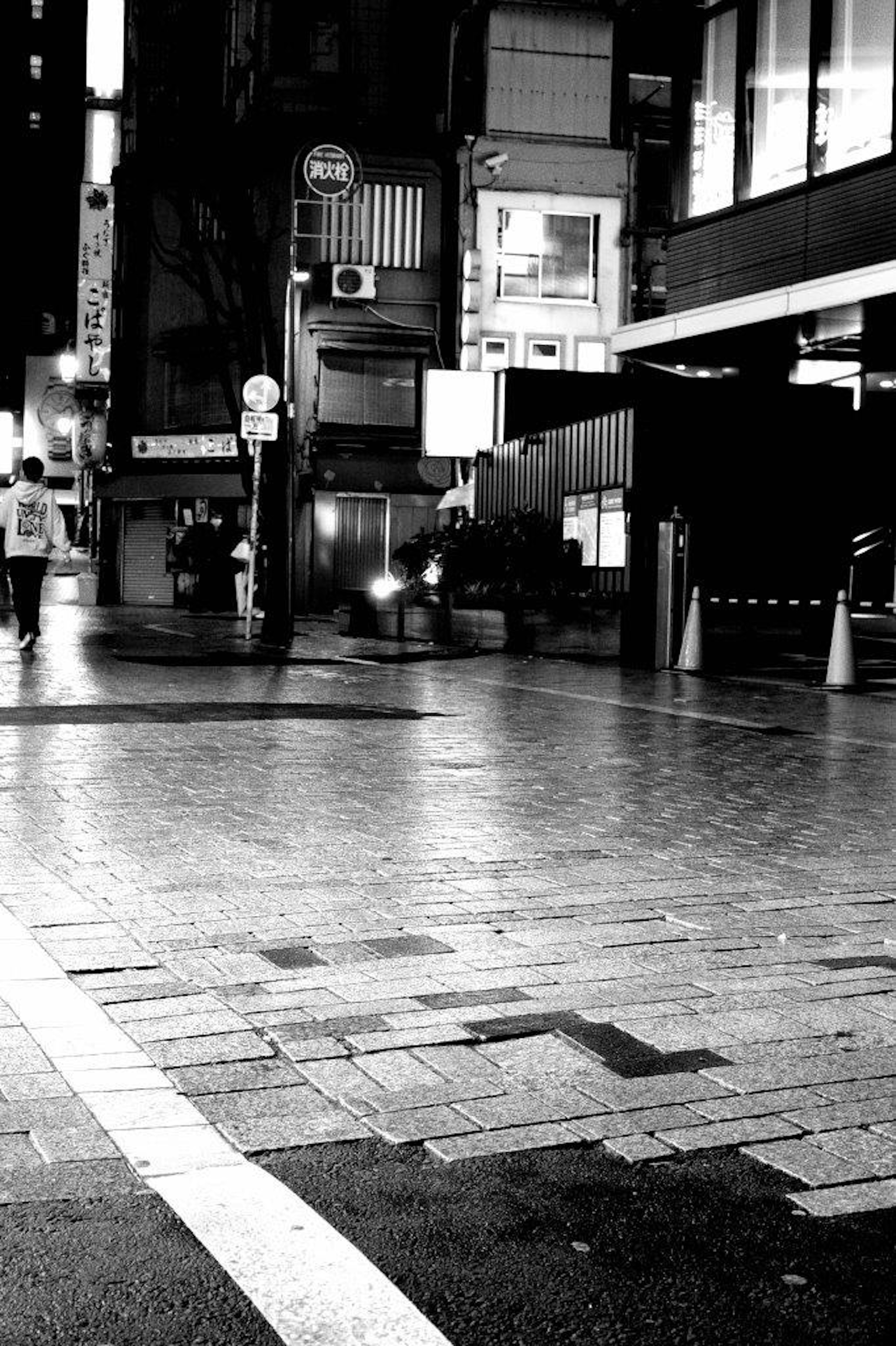 Scène urbaine en noir et blanc montrant des personnes marchant à un carrefour