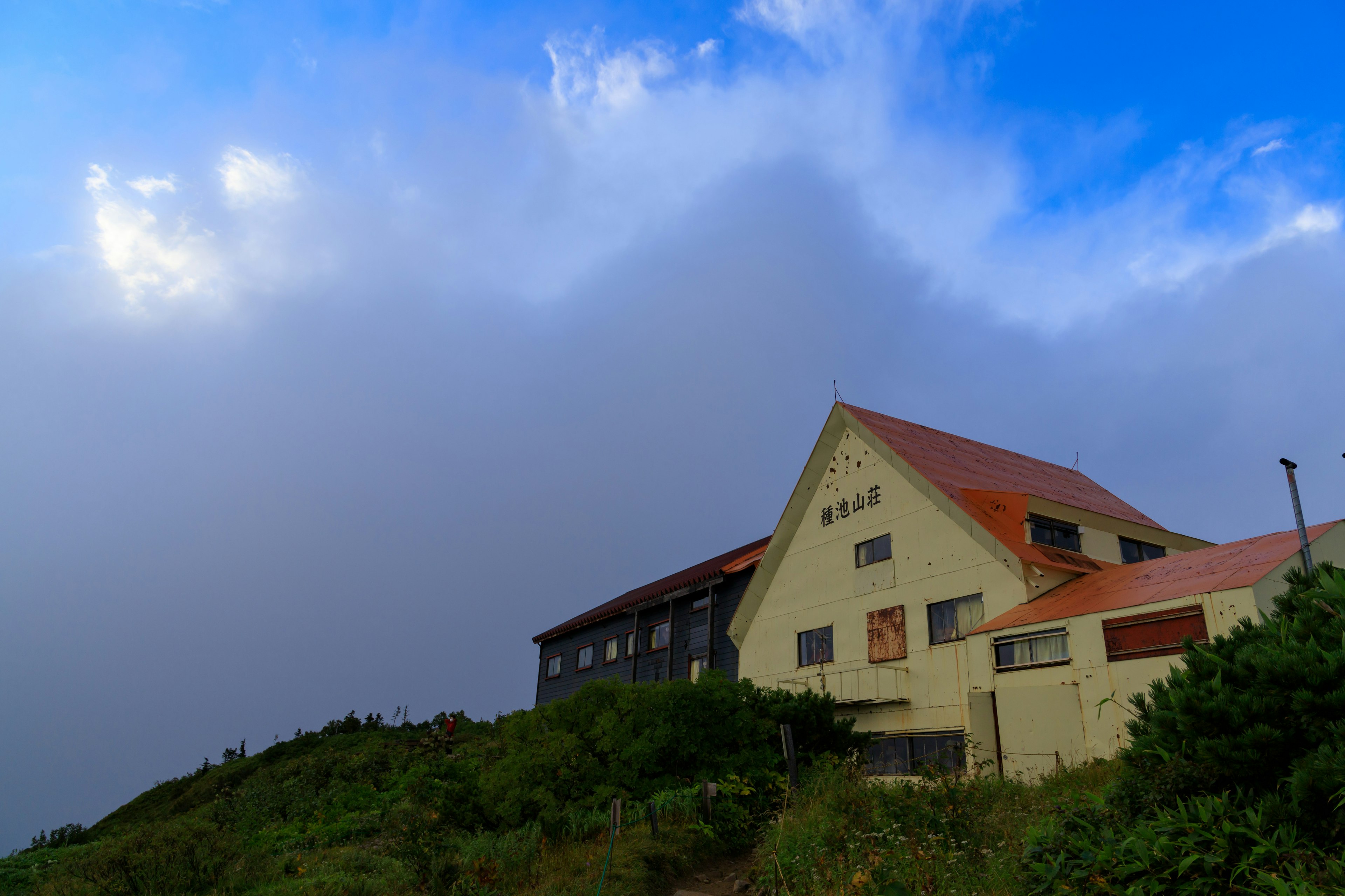 Ein Gebäude, das aus dem Nebel unter einem blauen Himmel auftaucht