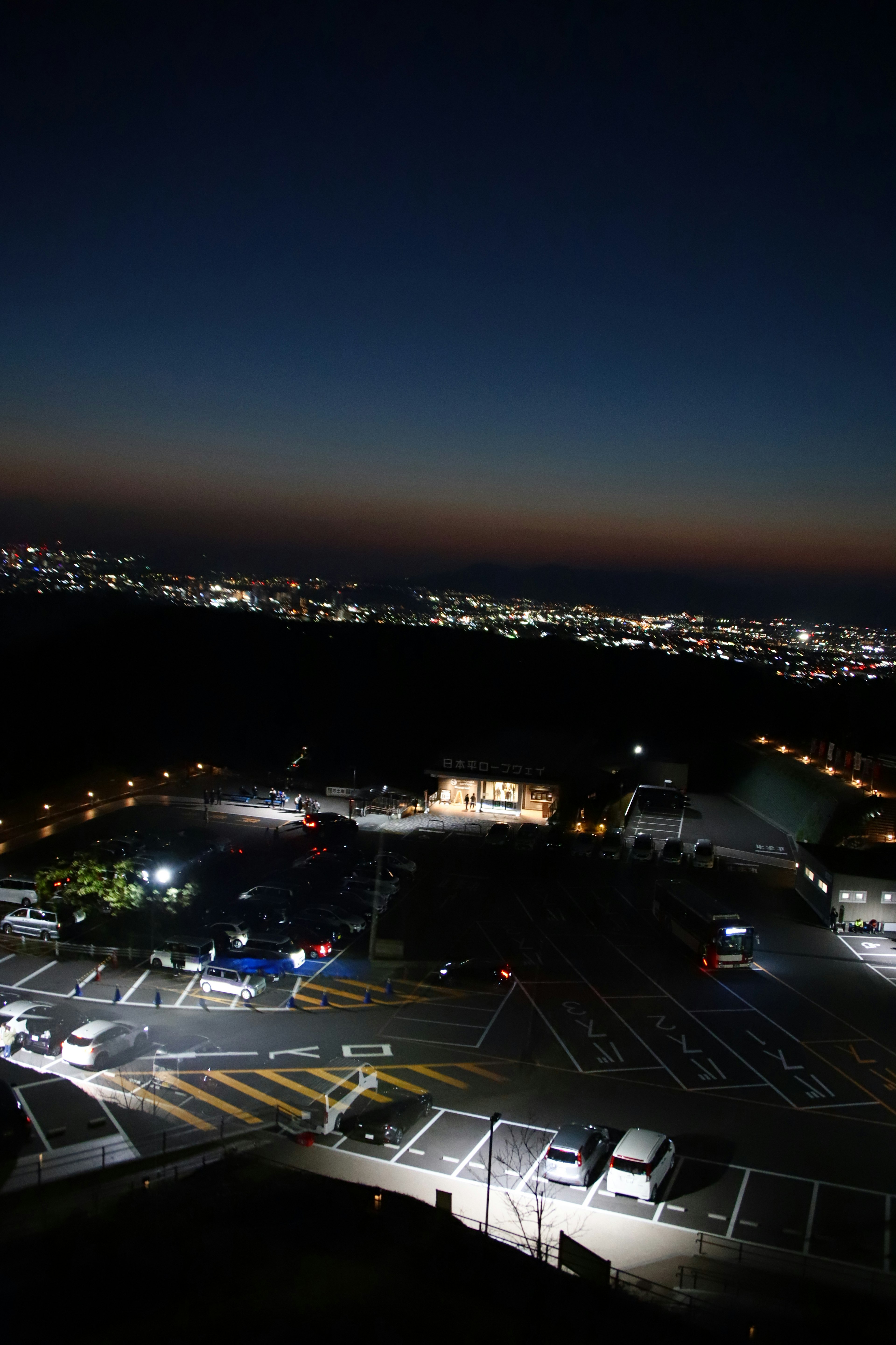 Vue panoramique d'un parking et des lumières de la ville la nuit