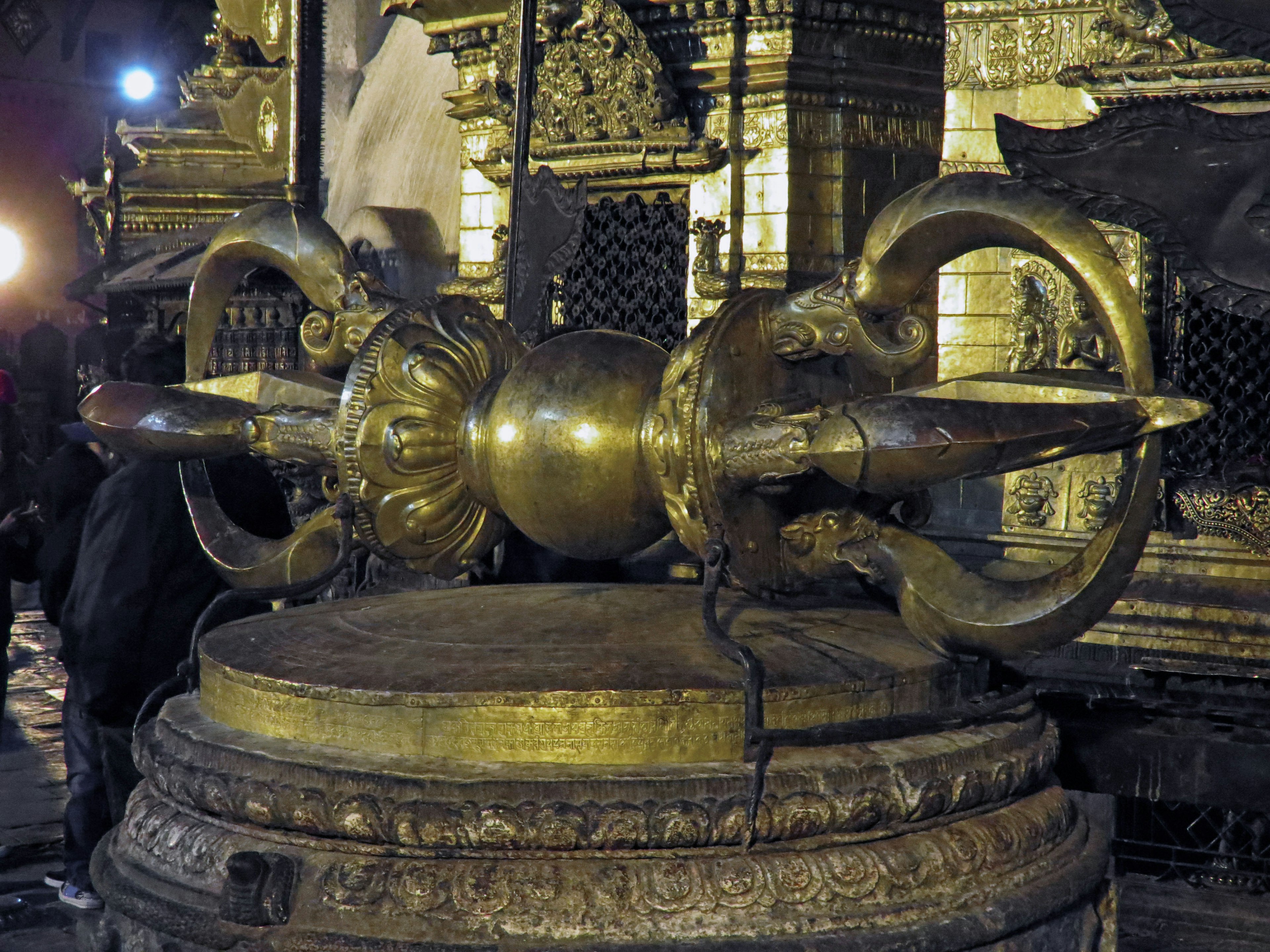 Decorative golden symbol in front of a temple at night