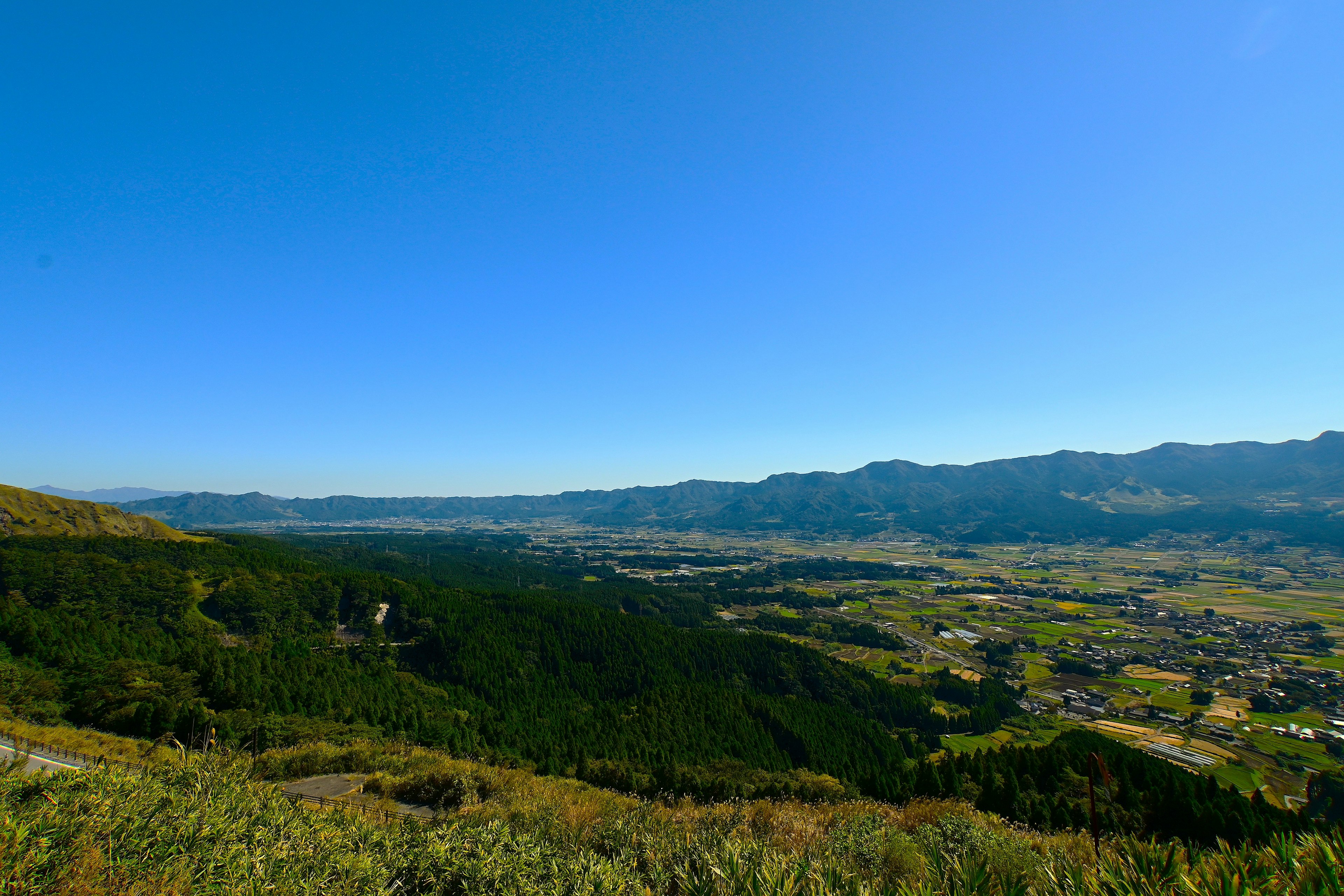 藍天之下綠色山丘的全景