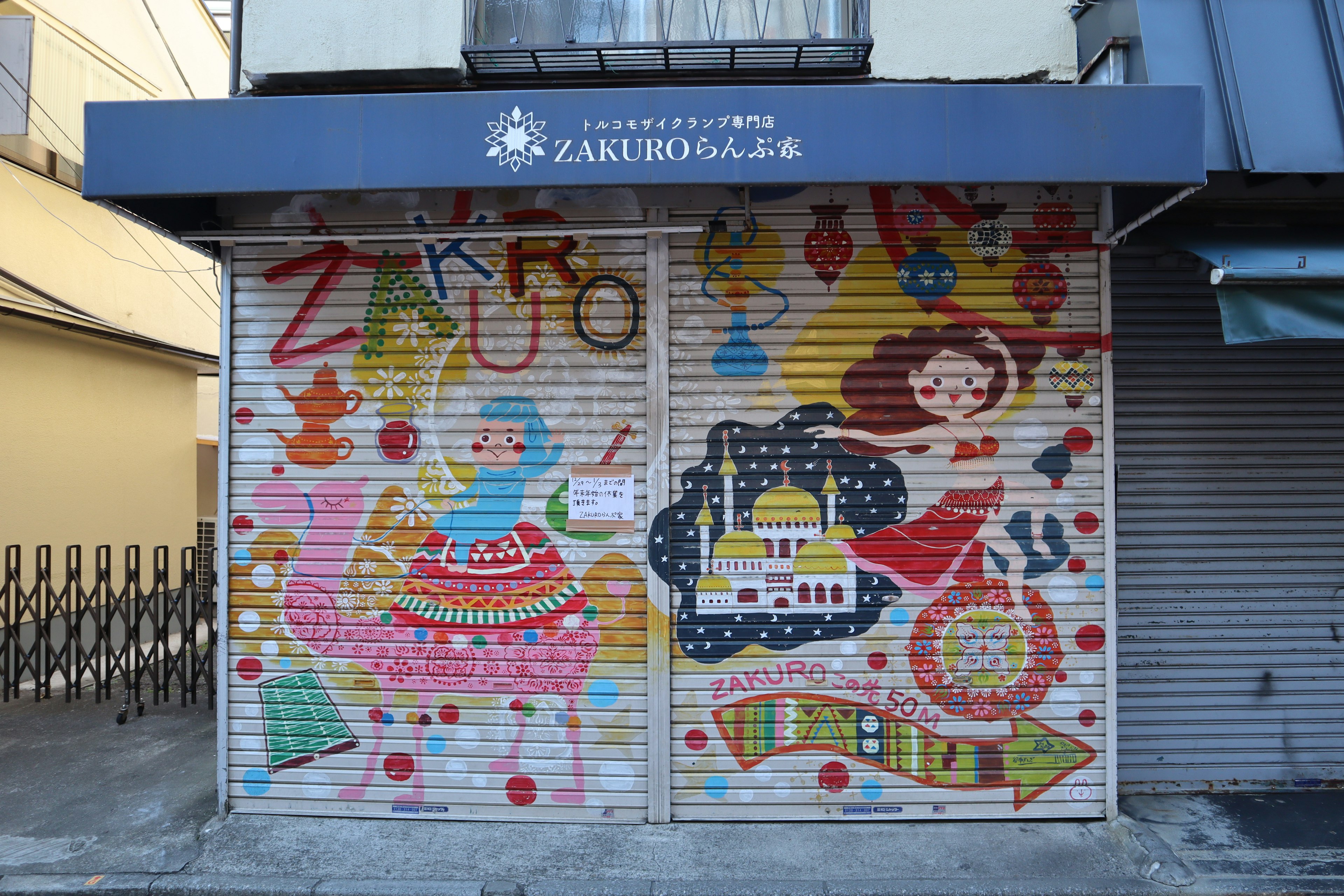 Colorful mural on a shutter featuring a whimsical design with characters and patterns