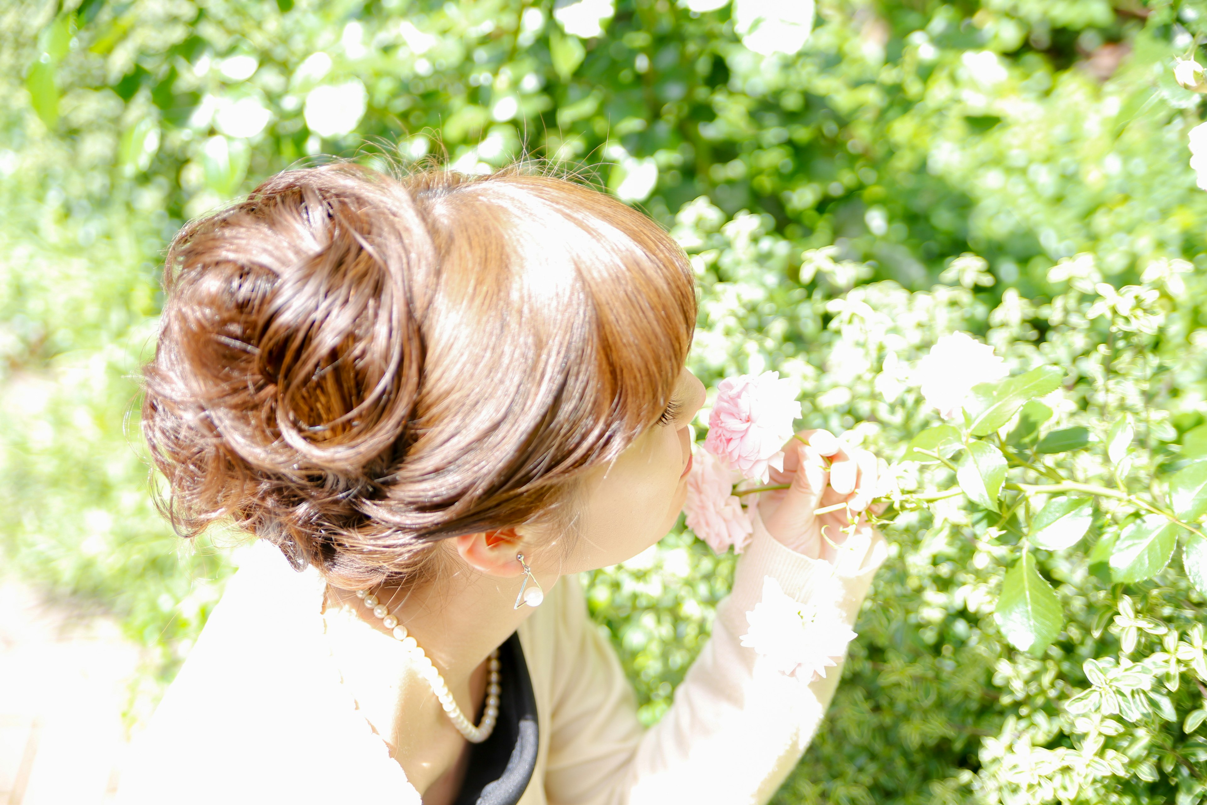 Una donna che annusa un fiore con uno sfondo verde e una luce soffusa