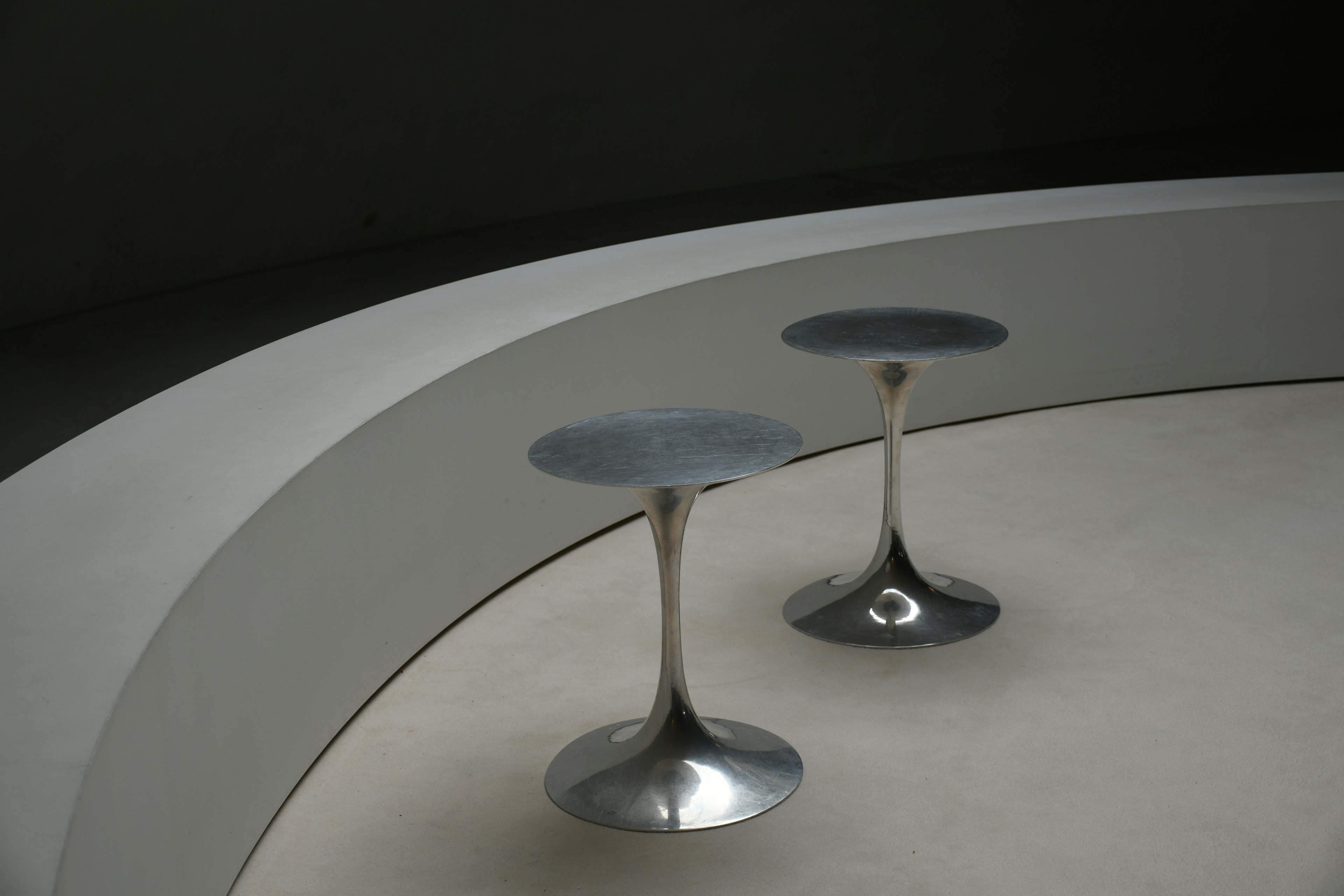 Modern interior featuring two metallic stools on a curved surface