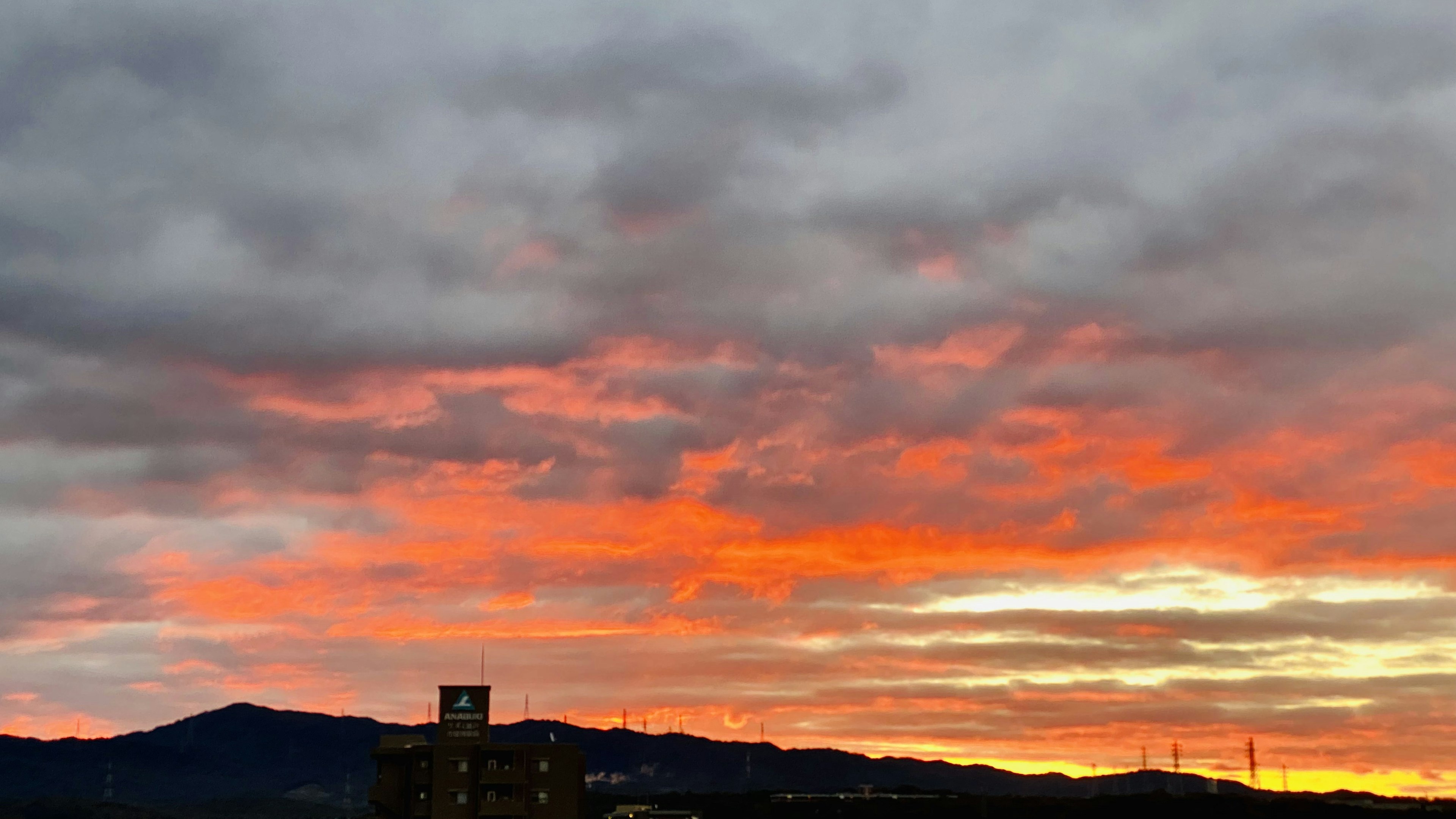 色彩斑斓的夕阳天空，背景有云和山