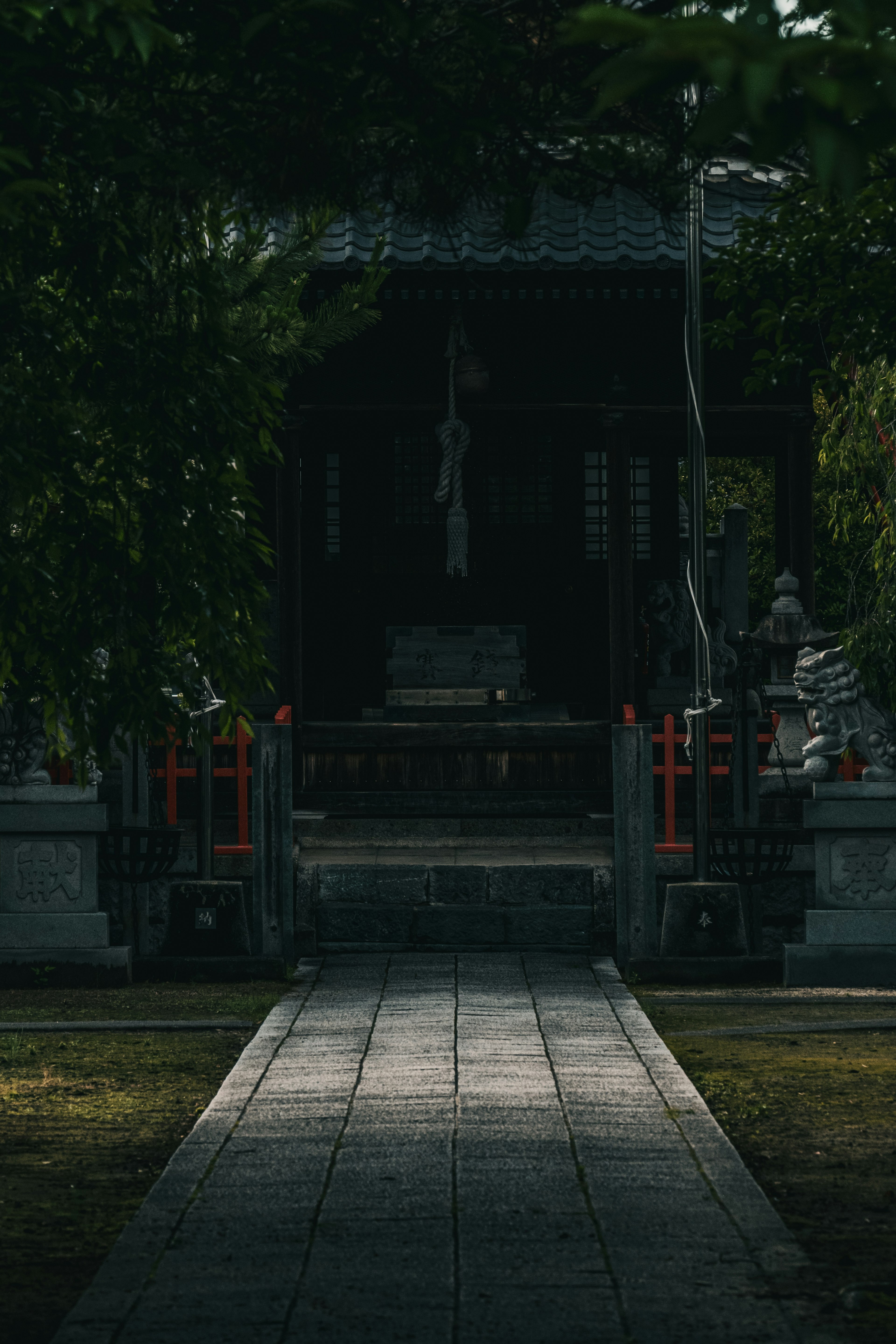 Entrance of a dark shrine with a stone pathway