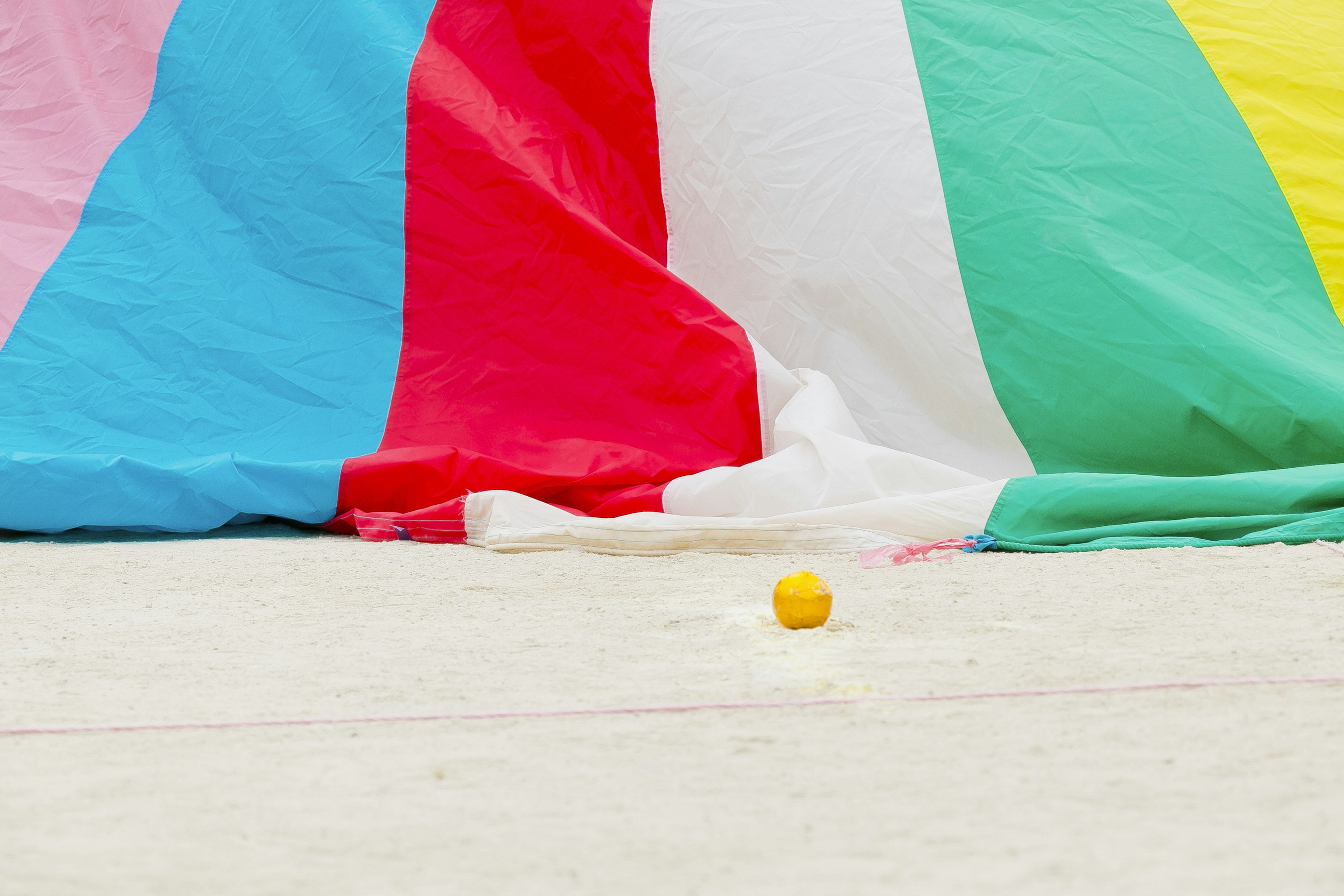 Colorful fabric backdrop with a yellow ball on the ground