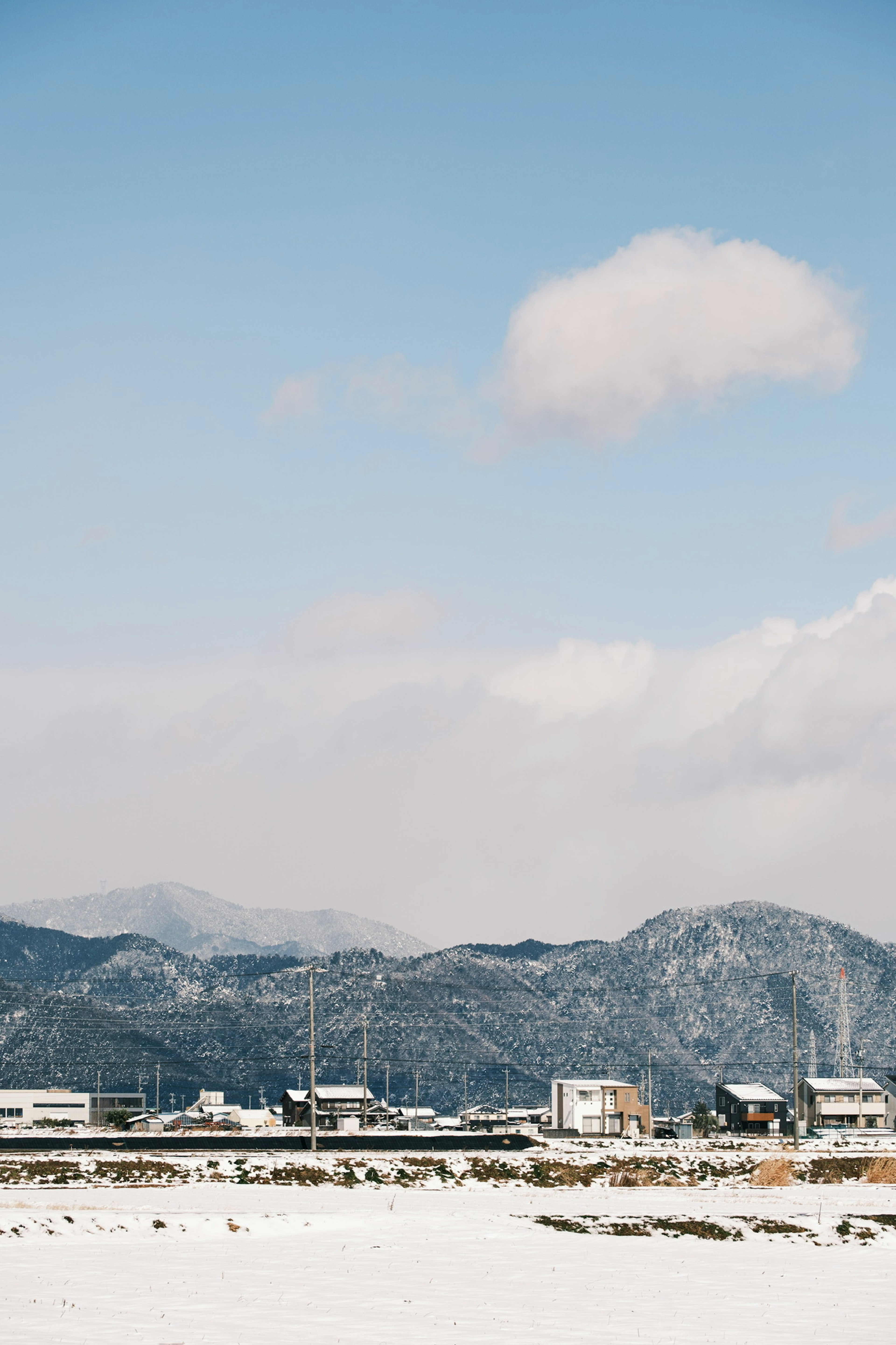 Snow-covered landscape with blue sky and mountains