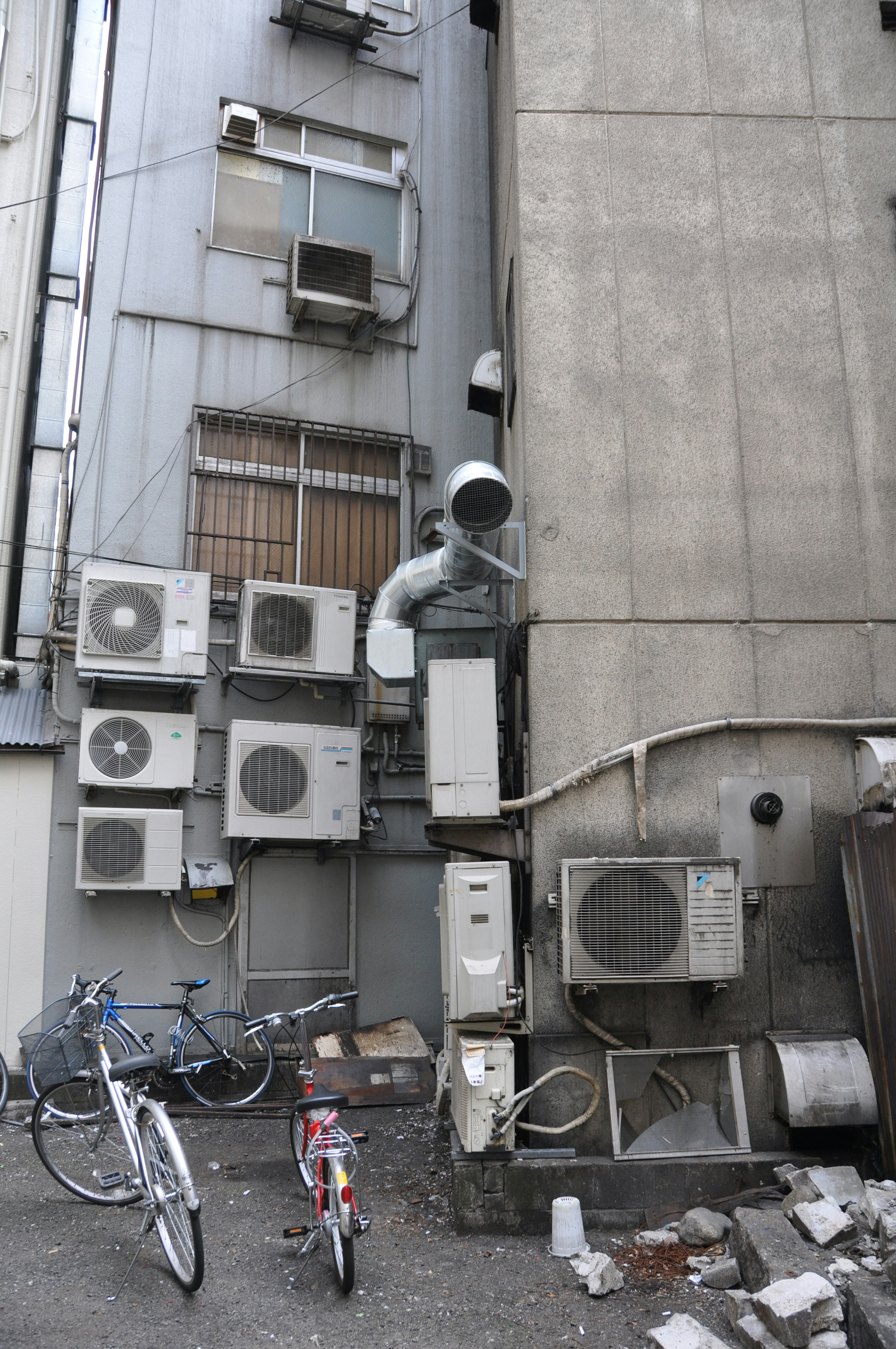 多台空调安装在建筑物侧面，附近有自行车