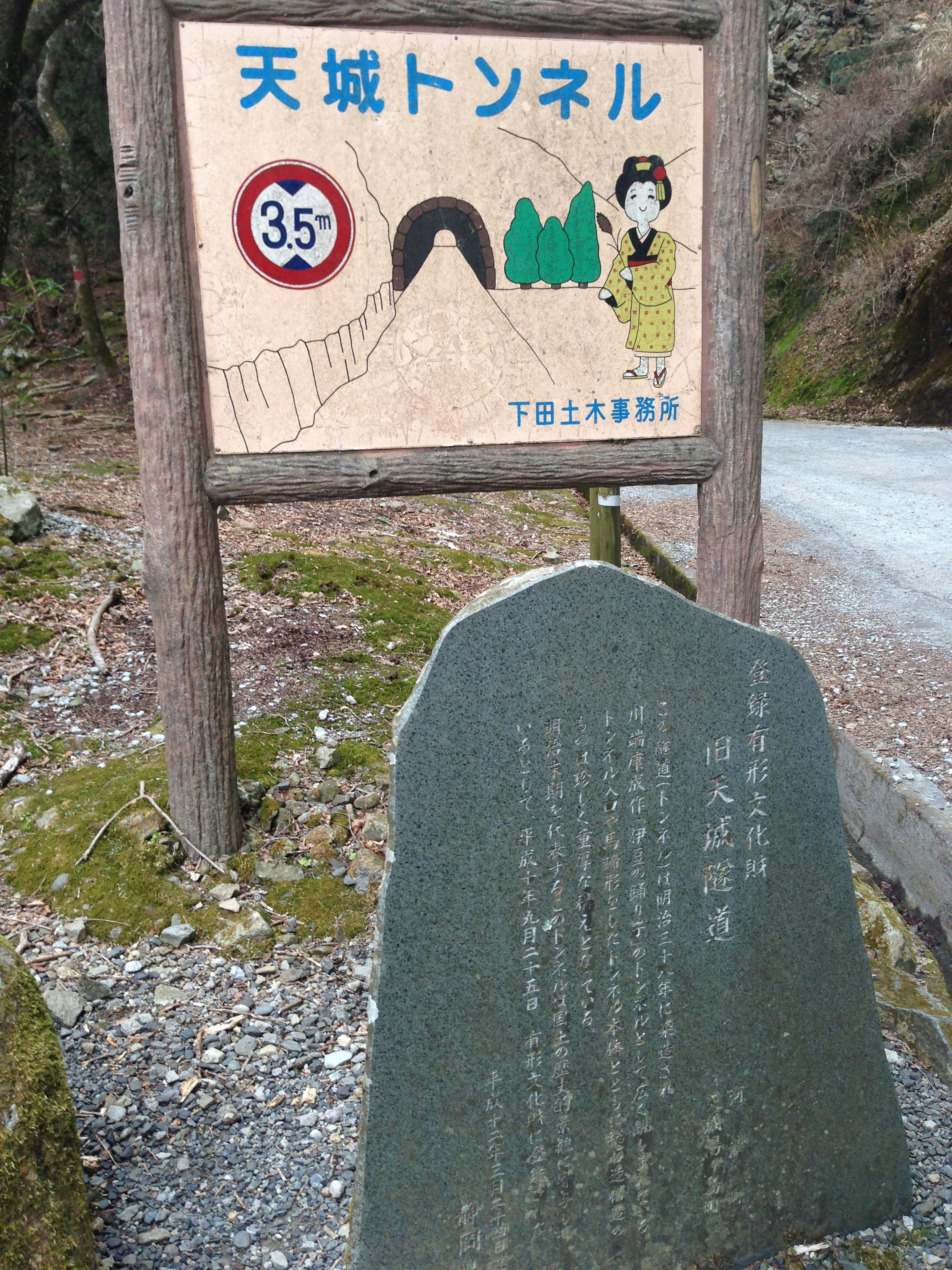 Sign for Amagi Tunnel with informational stone nearby