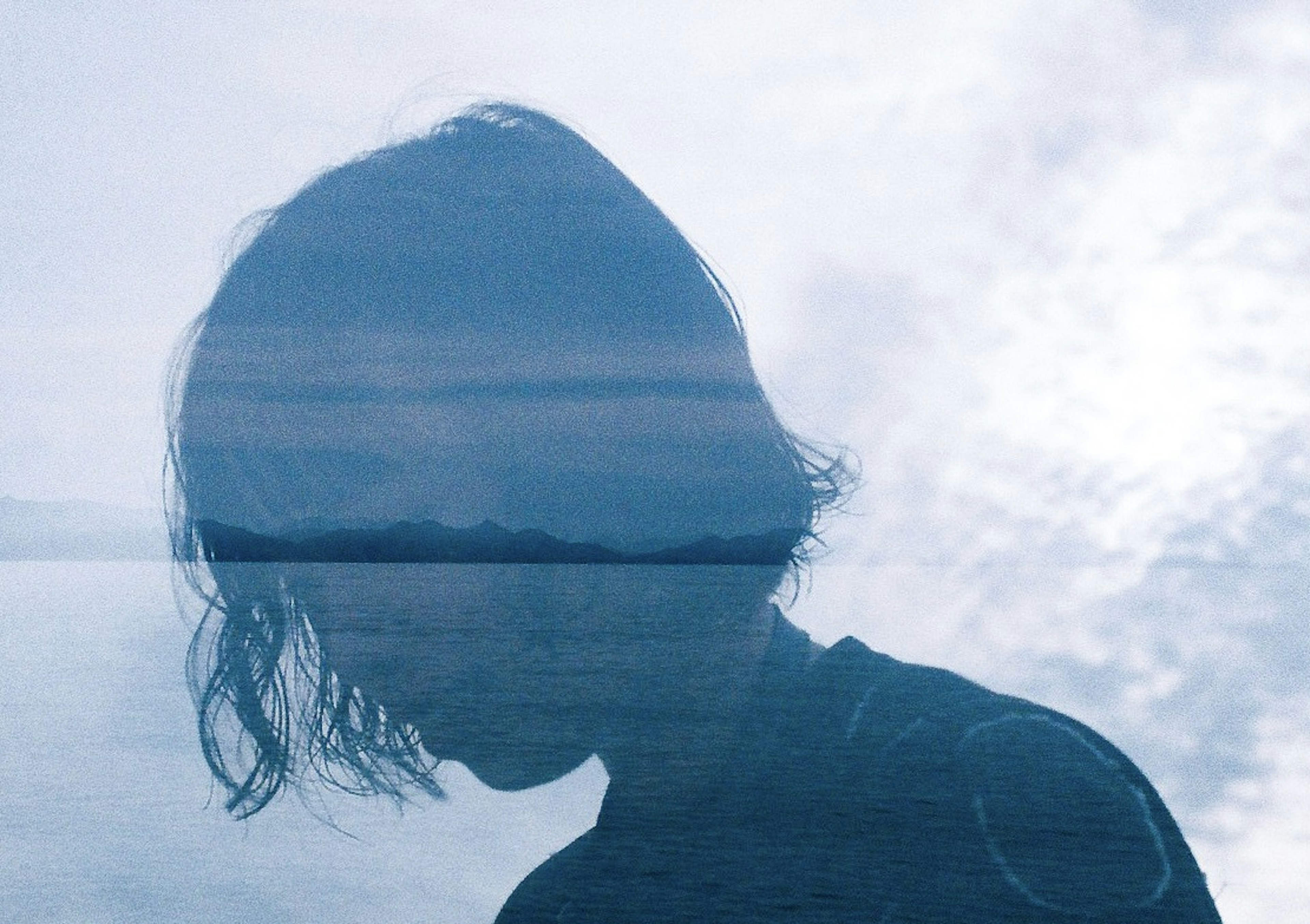 Silhouette of a person with blue ocean and sky overlay