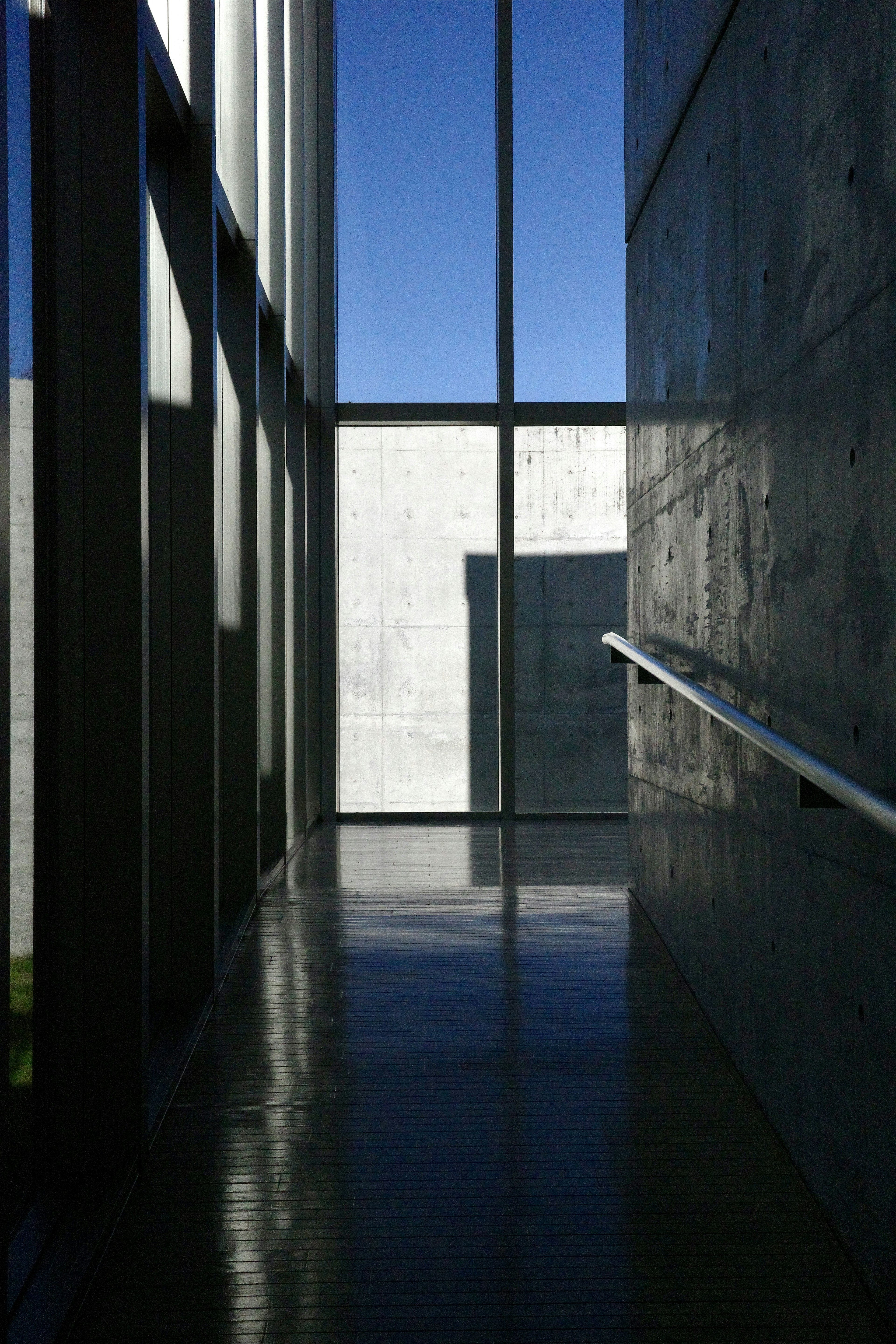 Foto de un pasillo con paredes de vidrio y un cielo azul brillante