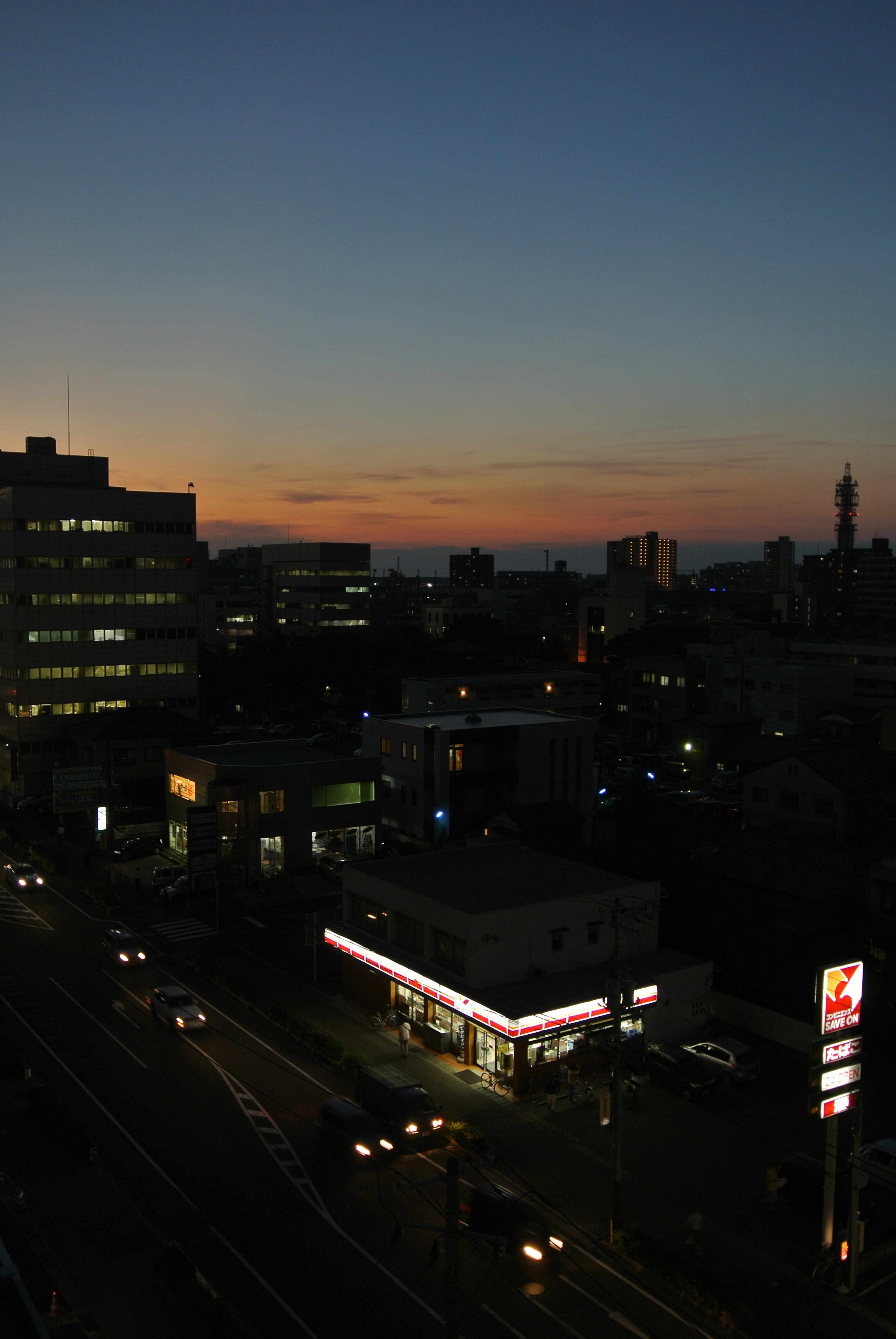 Cityscape at dusk featuring illuminated buildings and streets