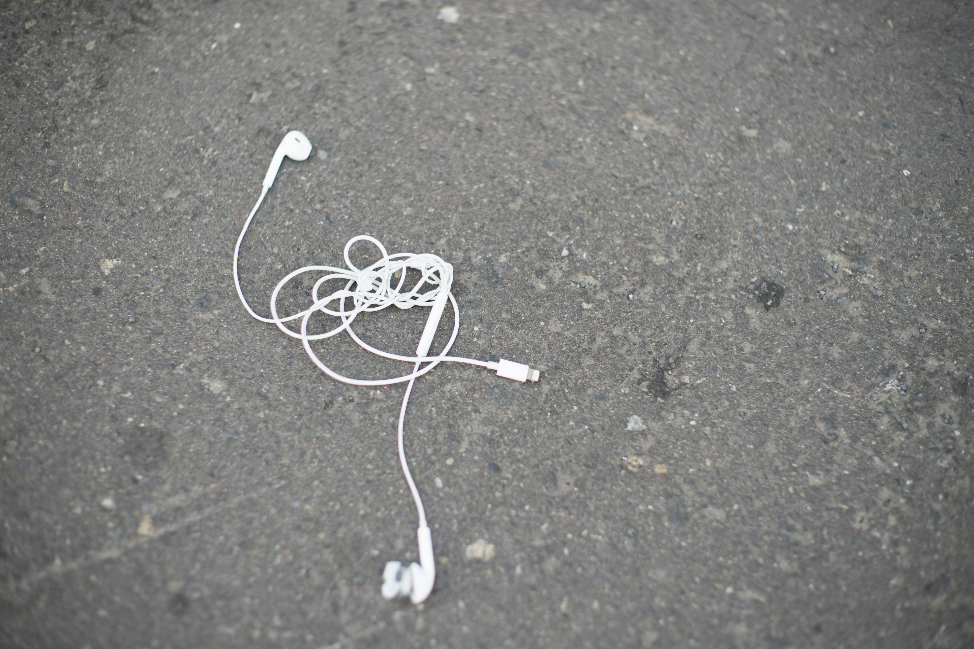 White earphones tangled on the ground