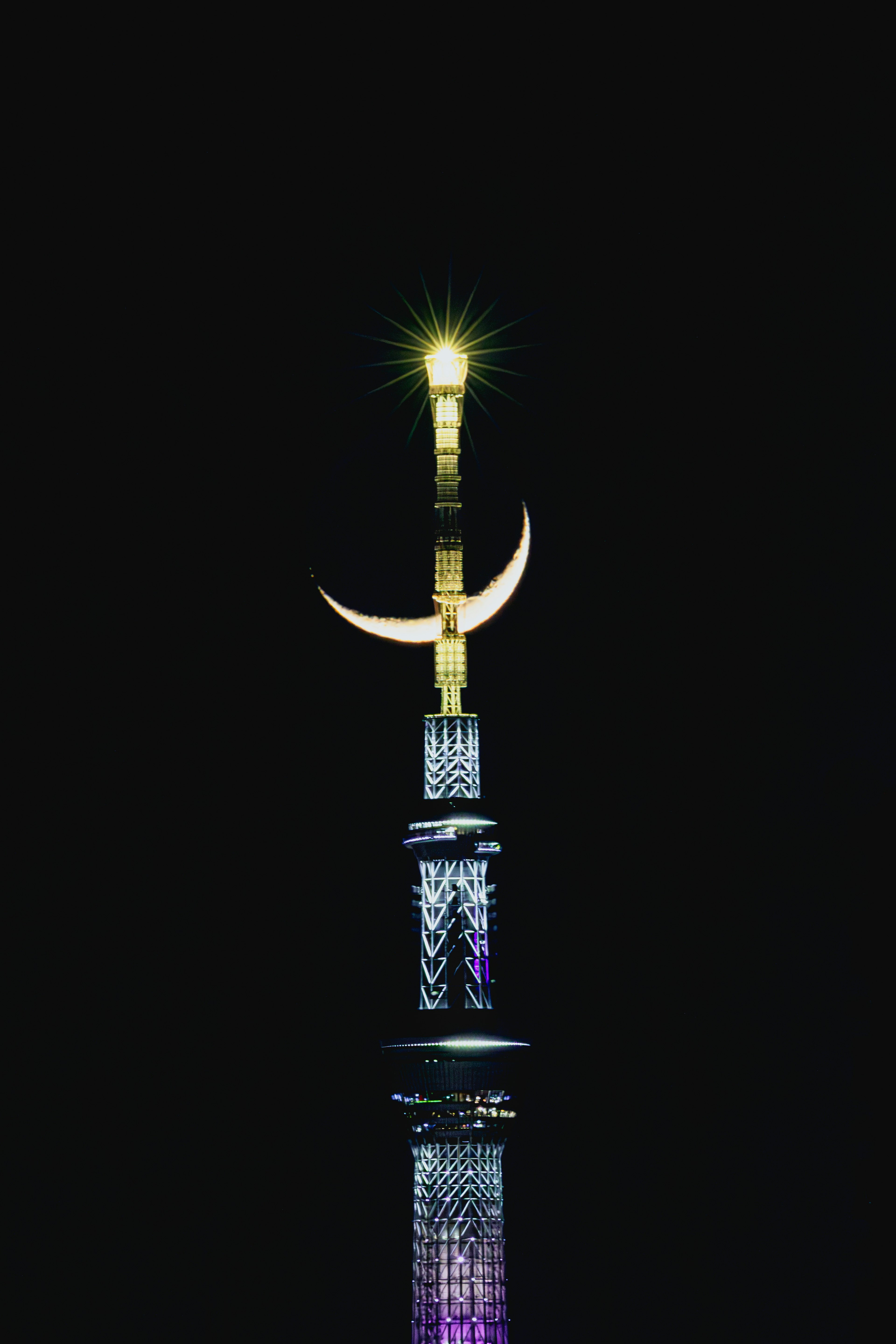 La estrella dorada y la media luna en la cima de un minarete de mezquita brillando en el cielo nocturno