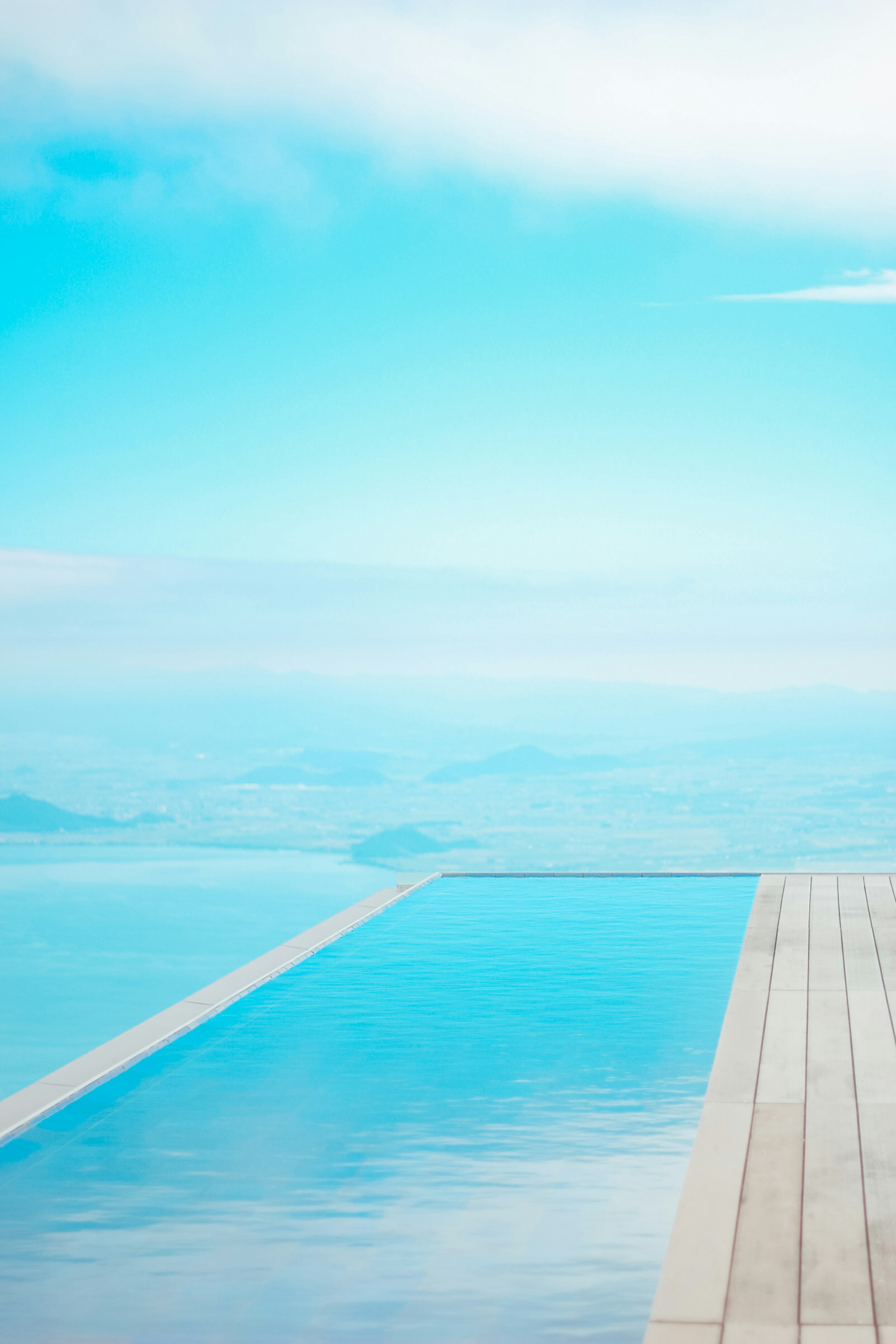 Impresionante vista de una piscina infinita con cielo azul y superficie de agua tranquila