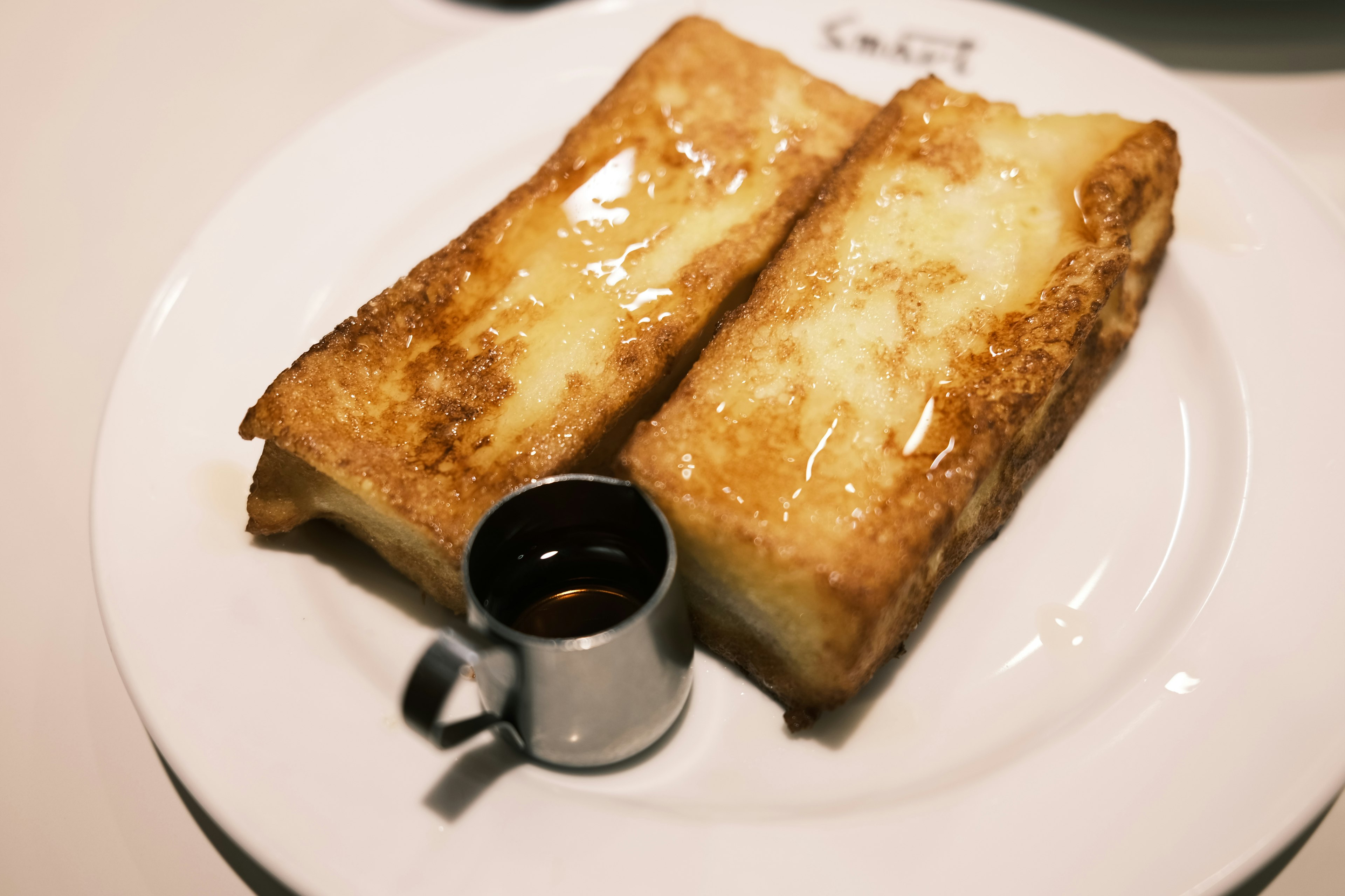 Plate of French toast drizzled with syrup