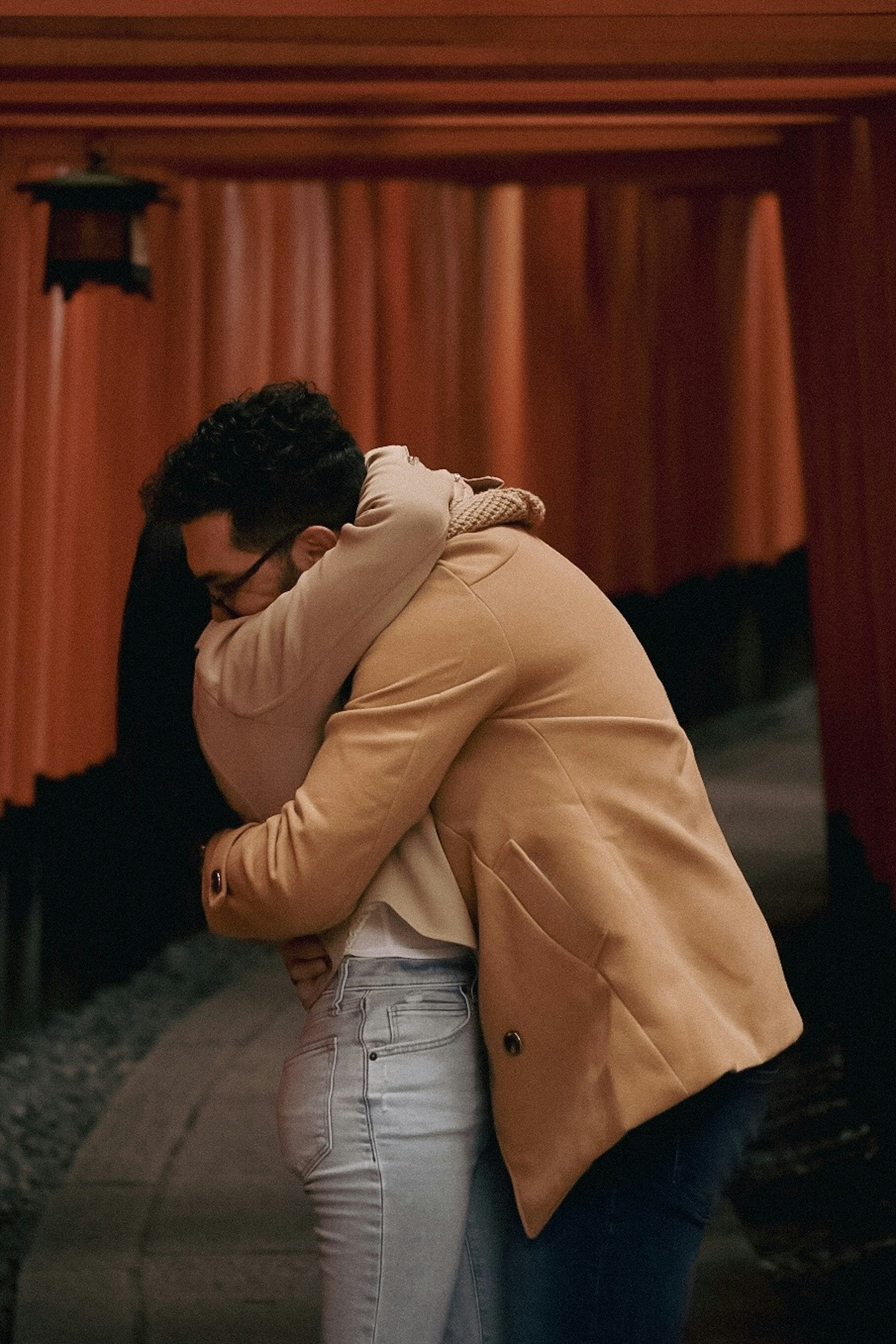 Couple hugging in an orange tunnel surrounded by traditional structures