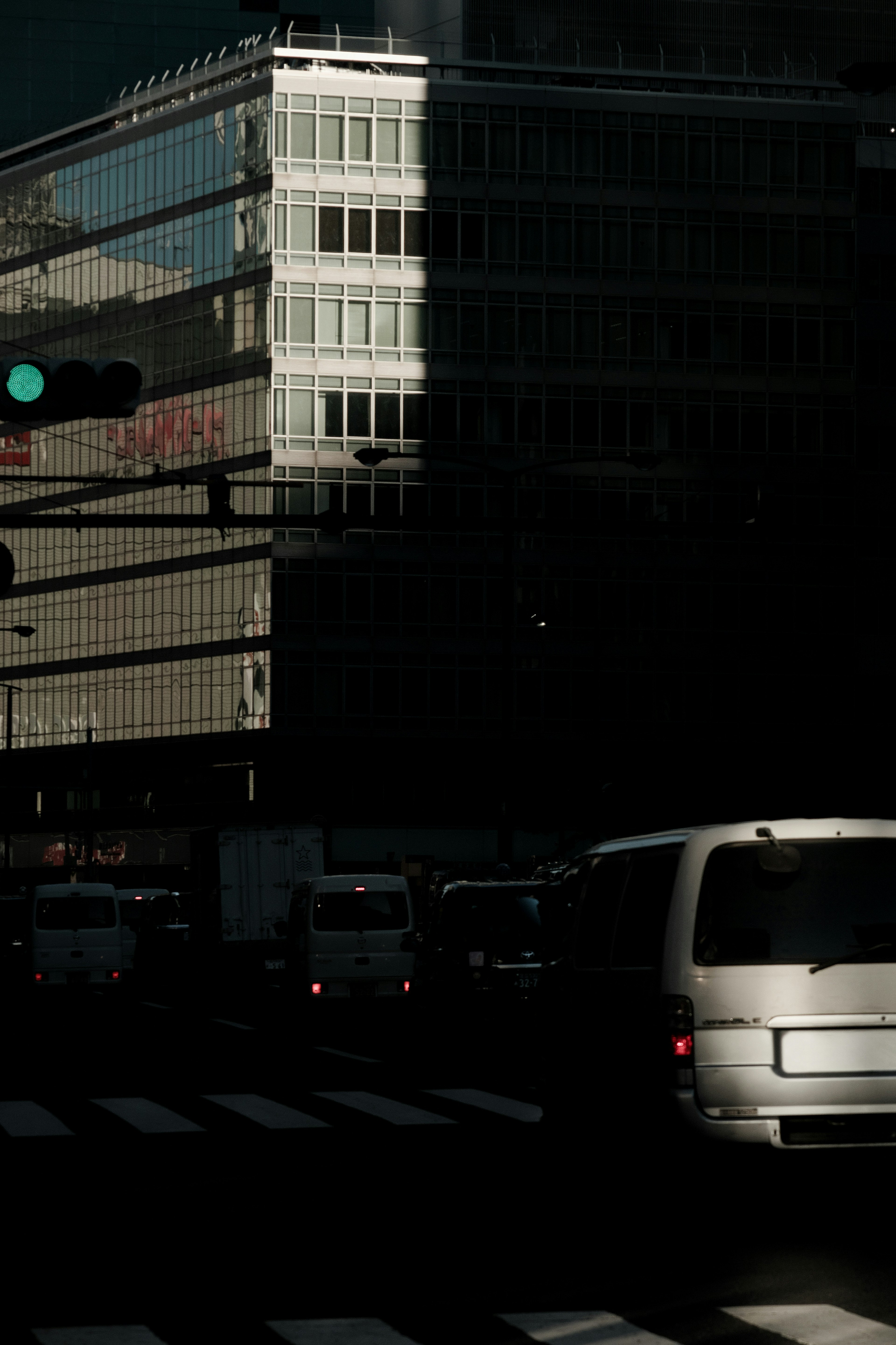 都市の交差点での車の流れとビルの反射