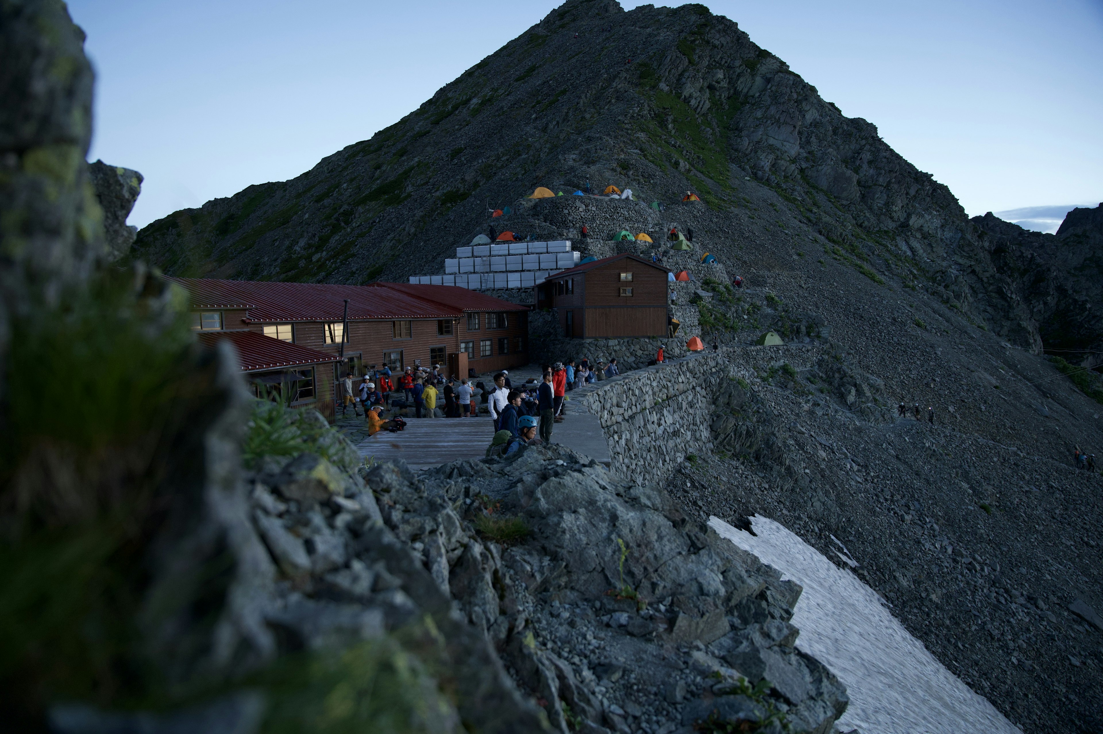 Berg-Hütte an einem Hang mit Dämmerungshimmel