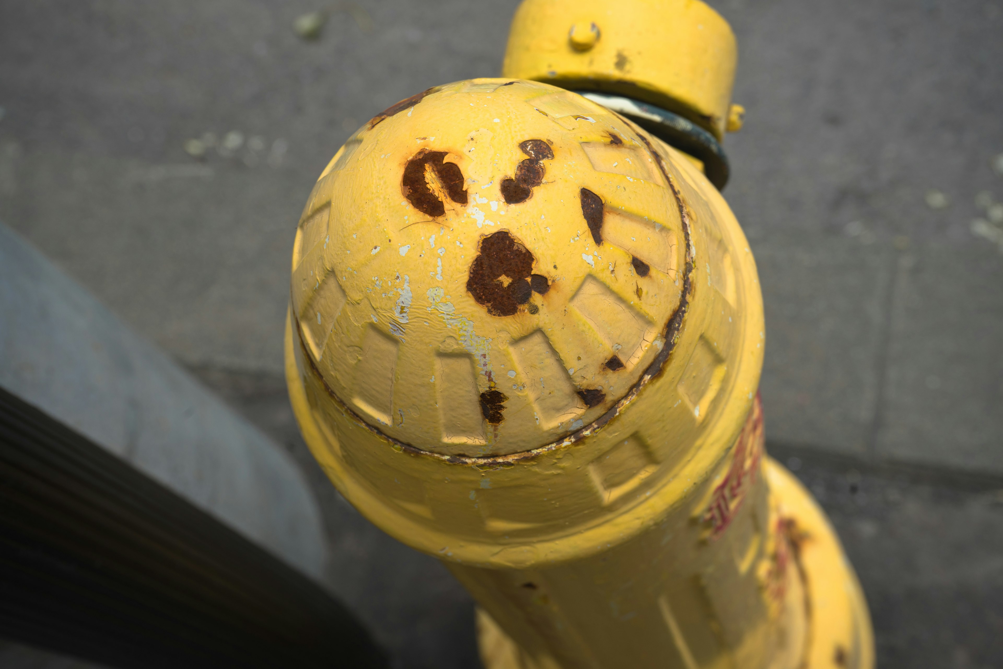 Vue de dessus d'une bouche d'incendie jaune rouillée