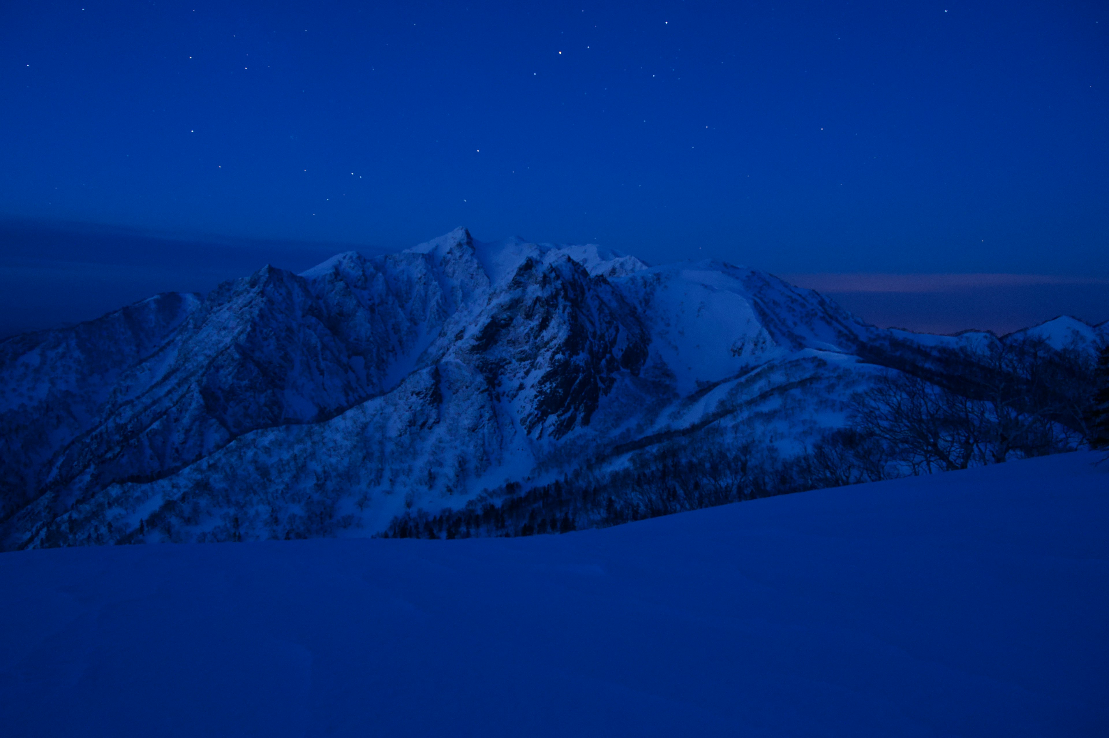 Schneebedeckte Berge unter einem blauen Nachthimmel