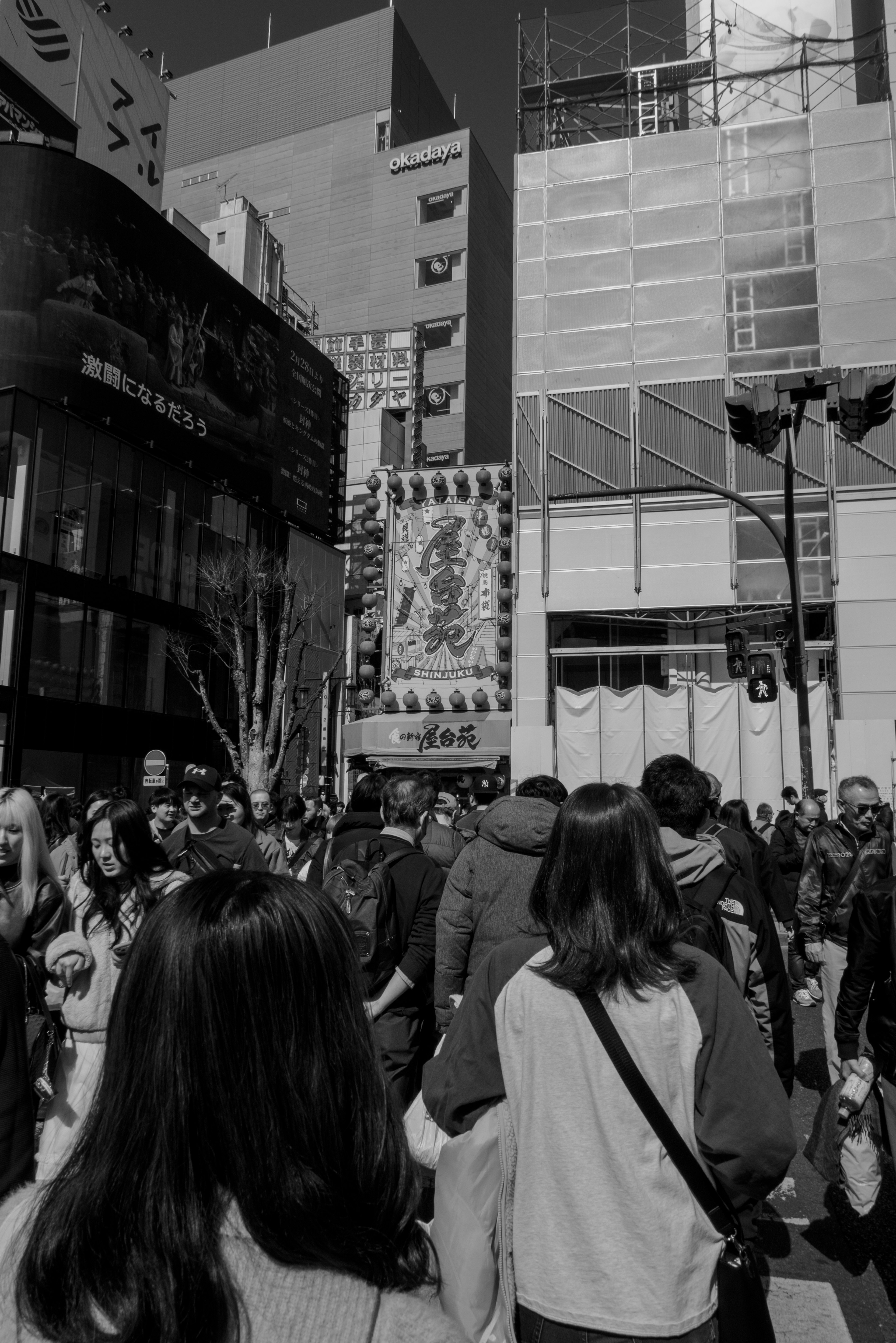 Crowded urban scene in black and white with many people gathered on the street