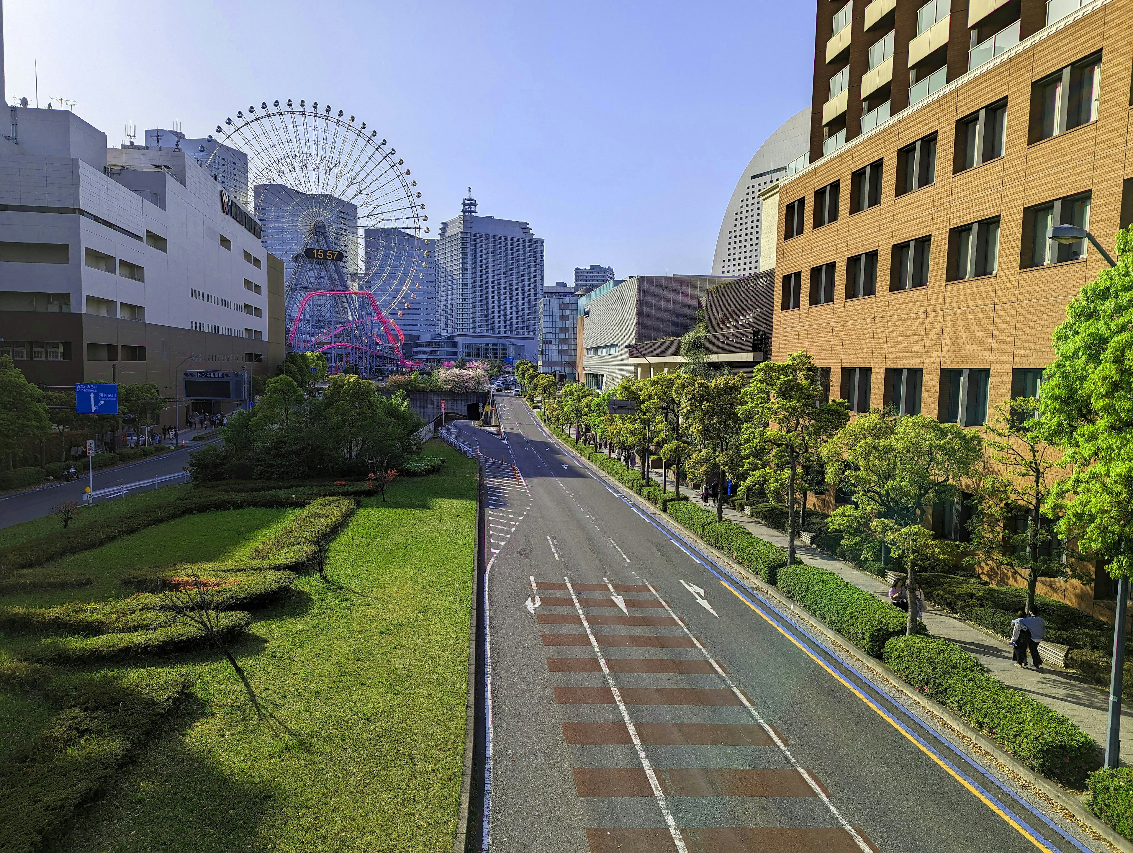 Urban street view featuring buildings and a Ferris wheel