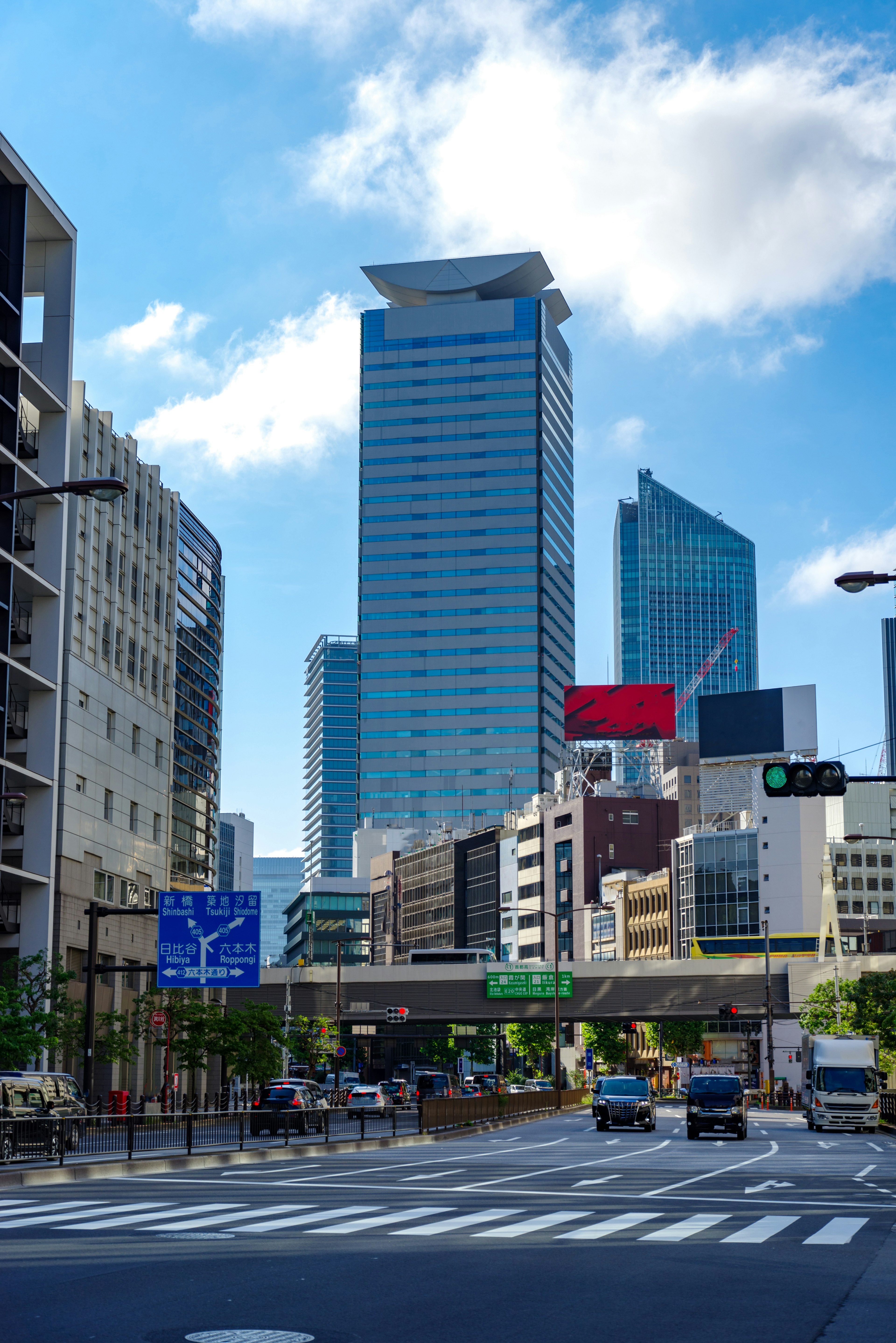 Cityscape featuring tall buildings and blue sky with traffic signs and vehicles