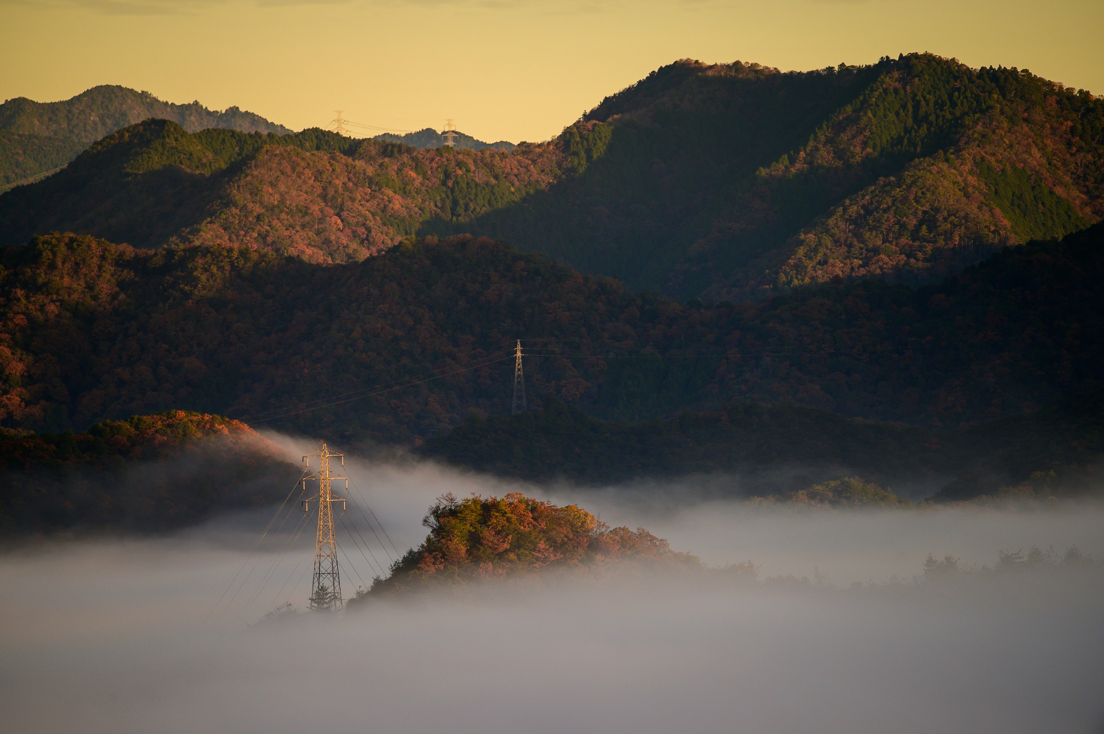 Montañas cubiertas de niebla con torres de comunicación