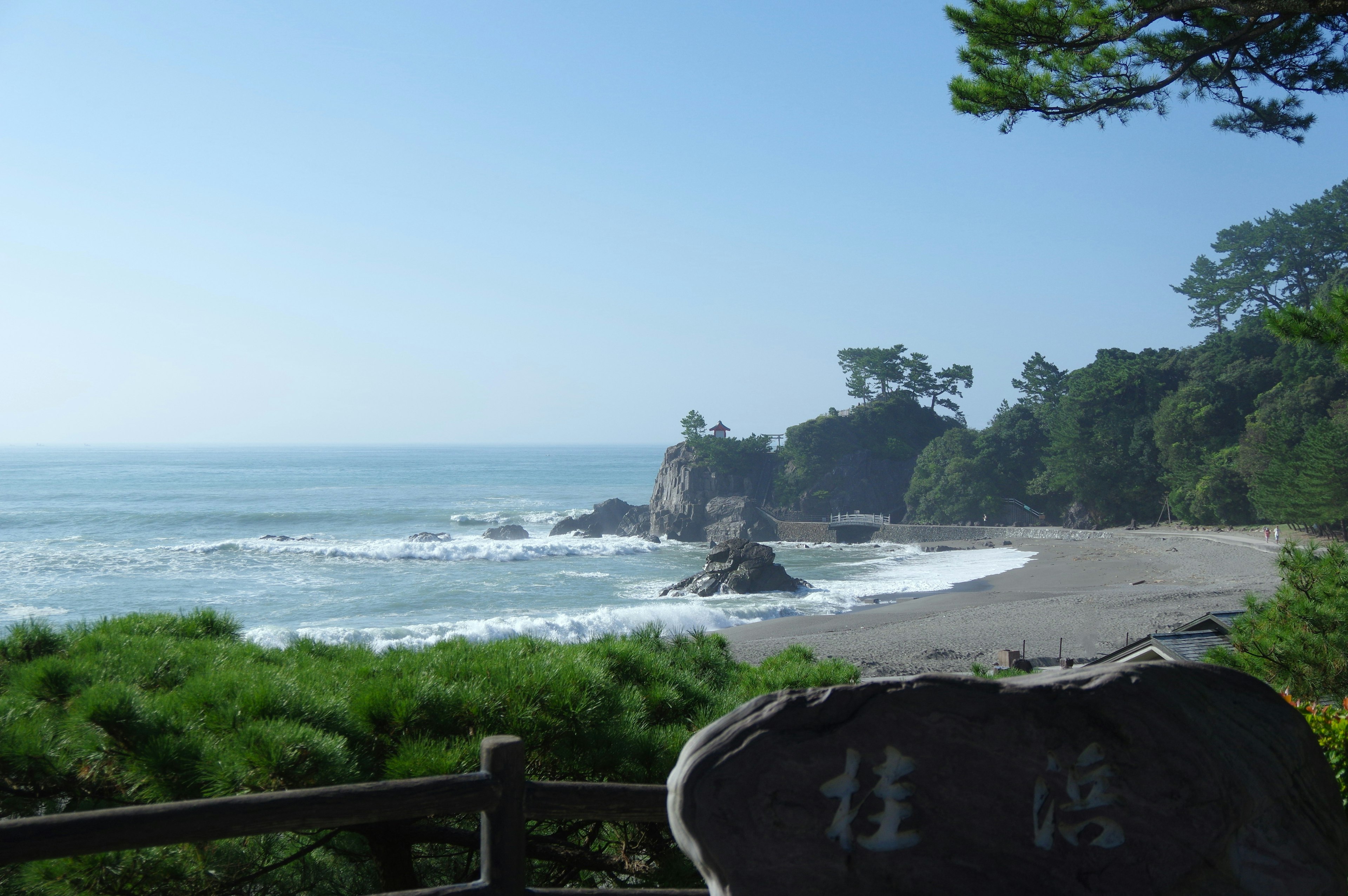 Paesaggio di spiaggia sereno con onde leggere e vegetazione lussureggiante