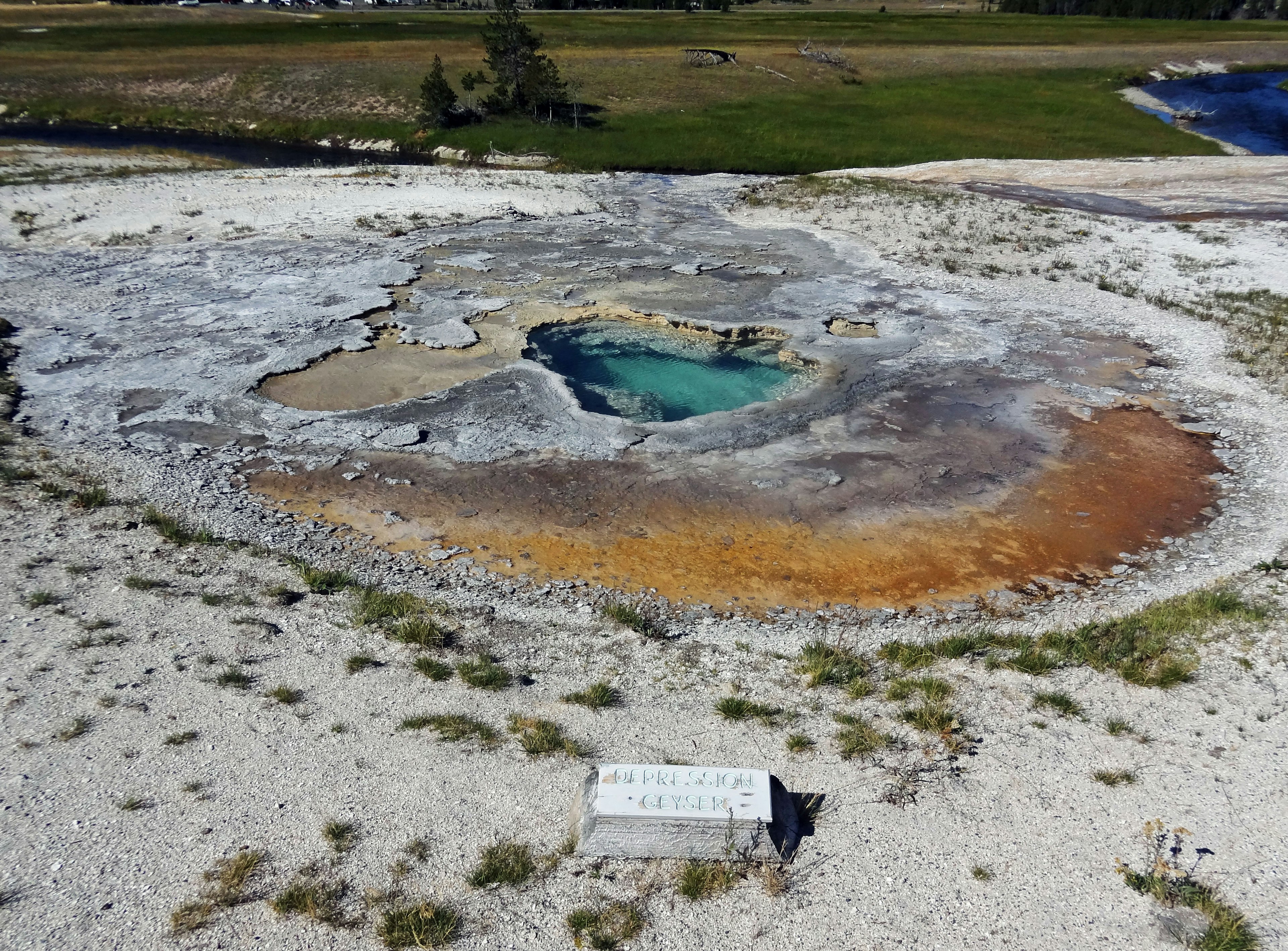 Aerial view of Yellowstone hot spring featuring turquoise water and colorful mineral deposits