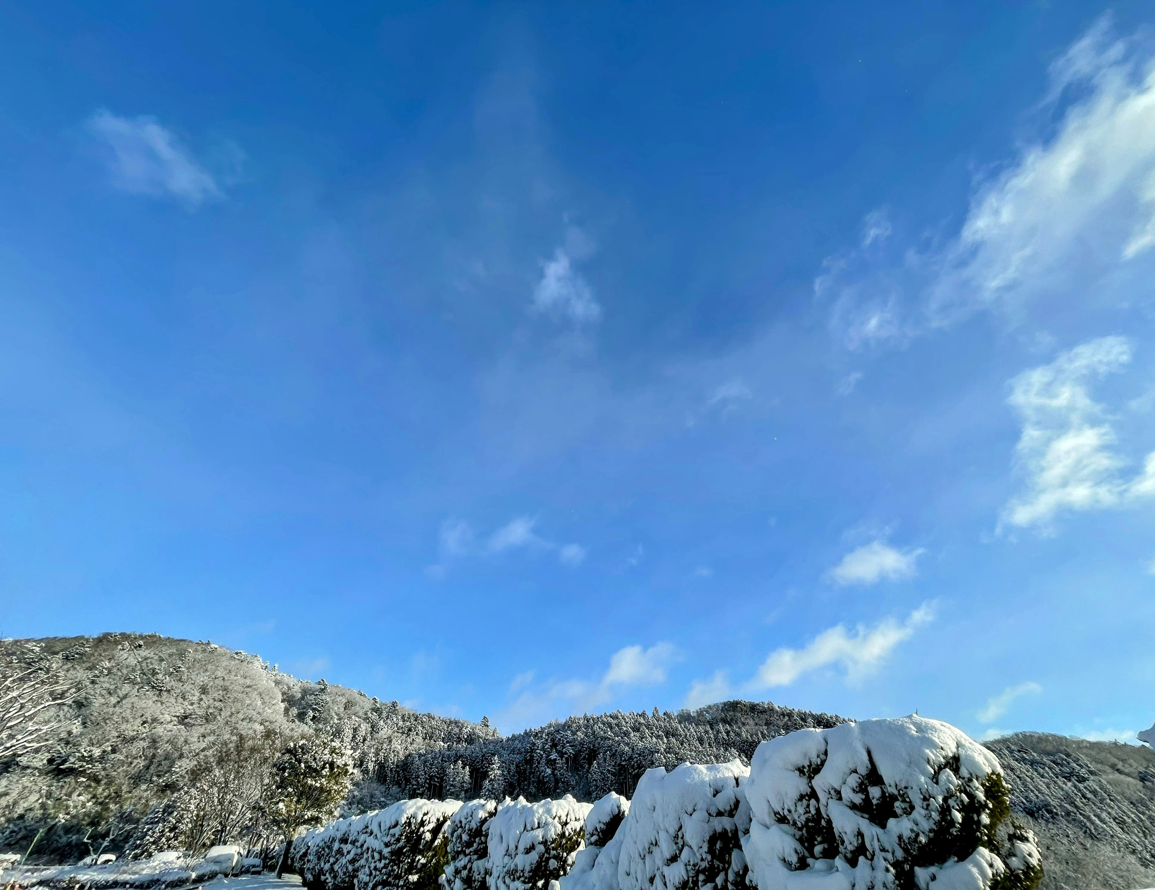 Landscape of snow-covered hills under a blue sky