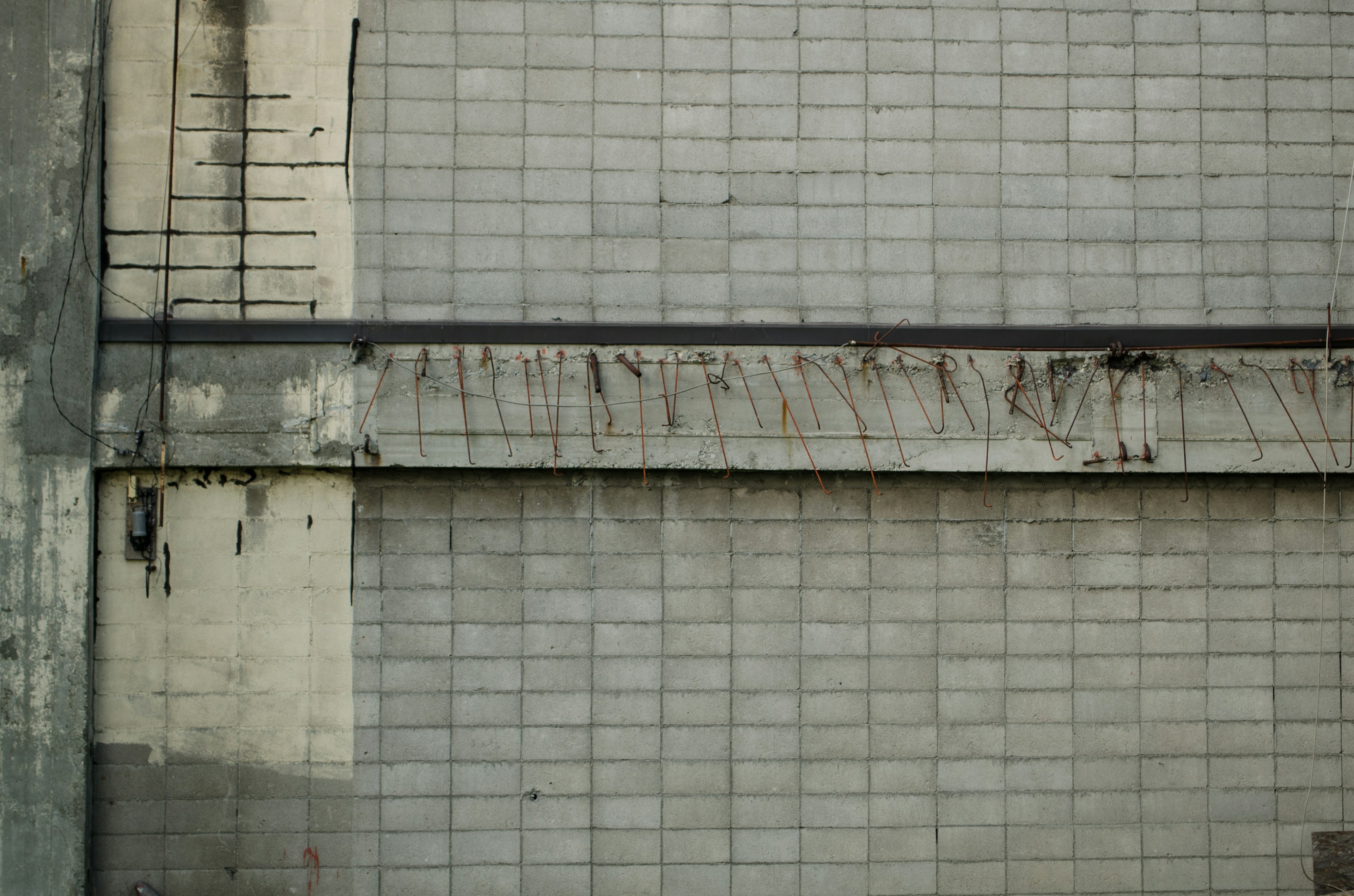 Primo piano di un muro piastrellato grigio che mostra macchie e usura