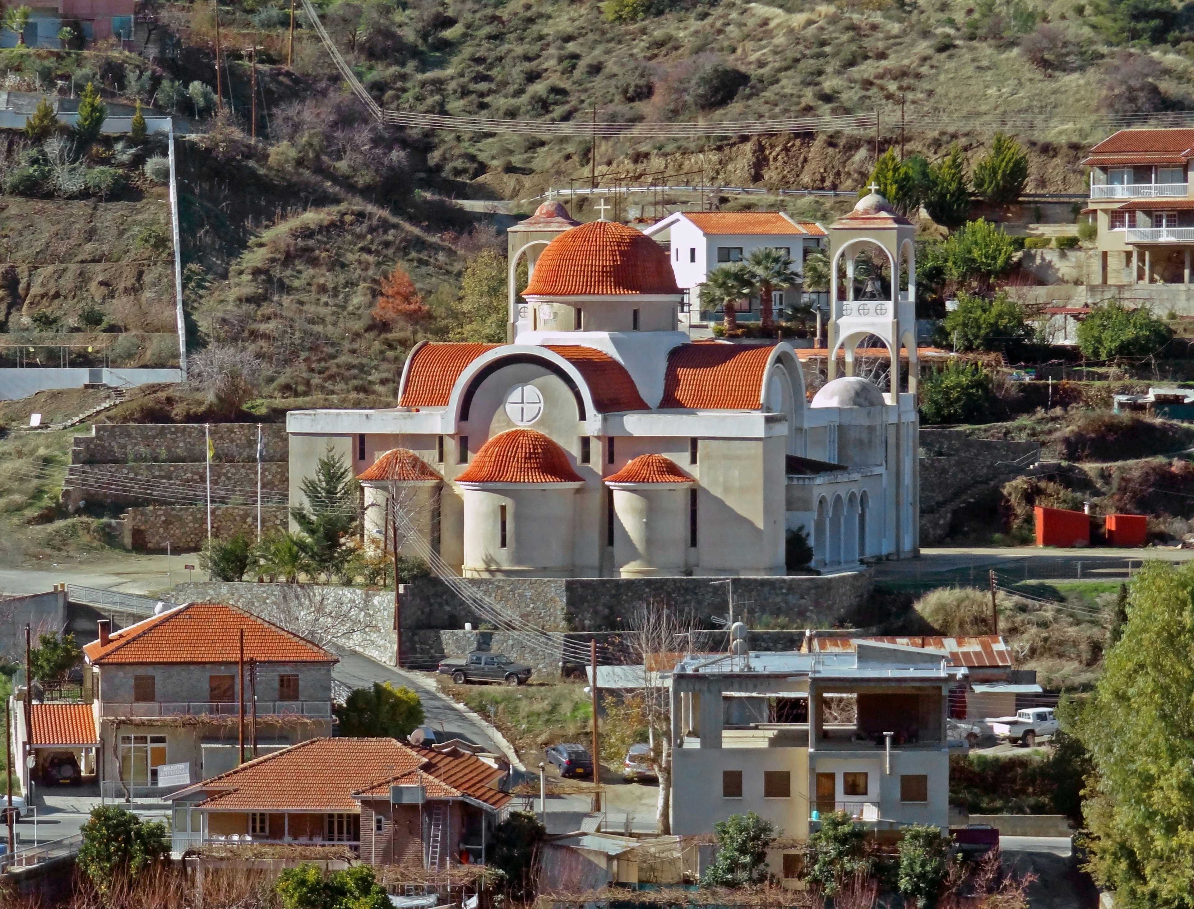 Una vista panoramica di un villaggio con una chiesa a tetto rosso e case in montagna