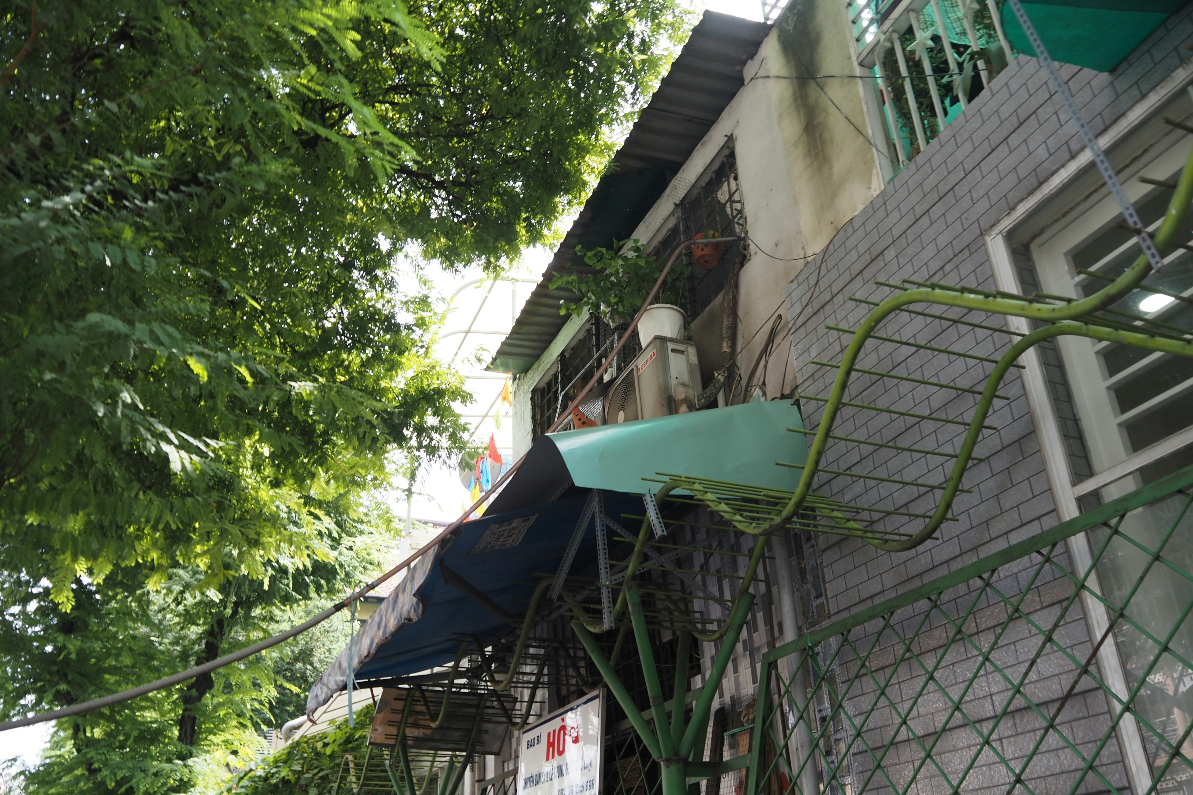 木々に囲まれた建物の外観と緑色の屋根