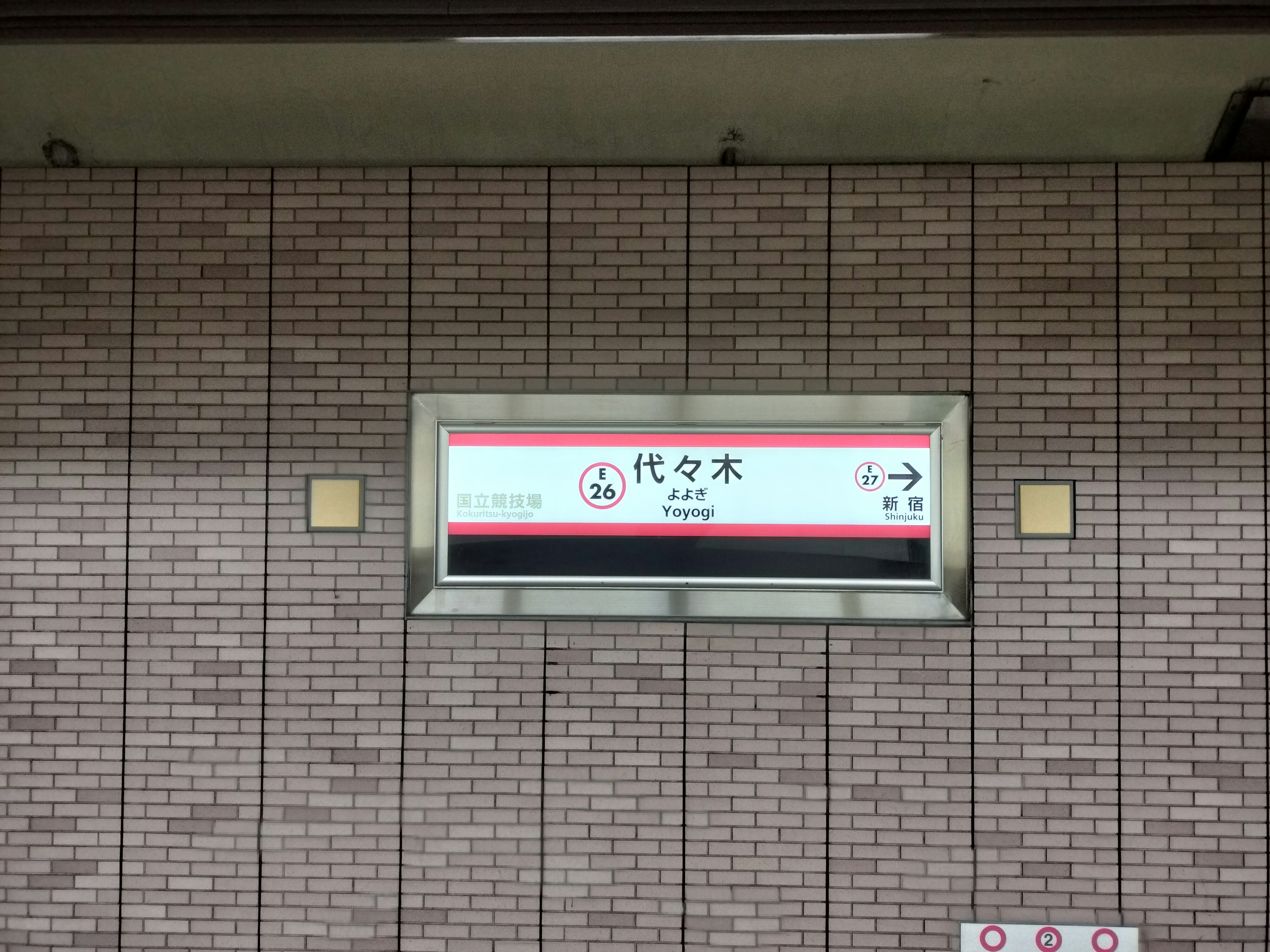 代々木駅の駅名看板とレンガの壁の部分