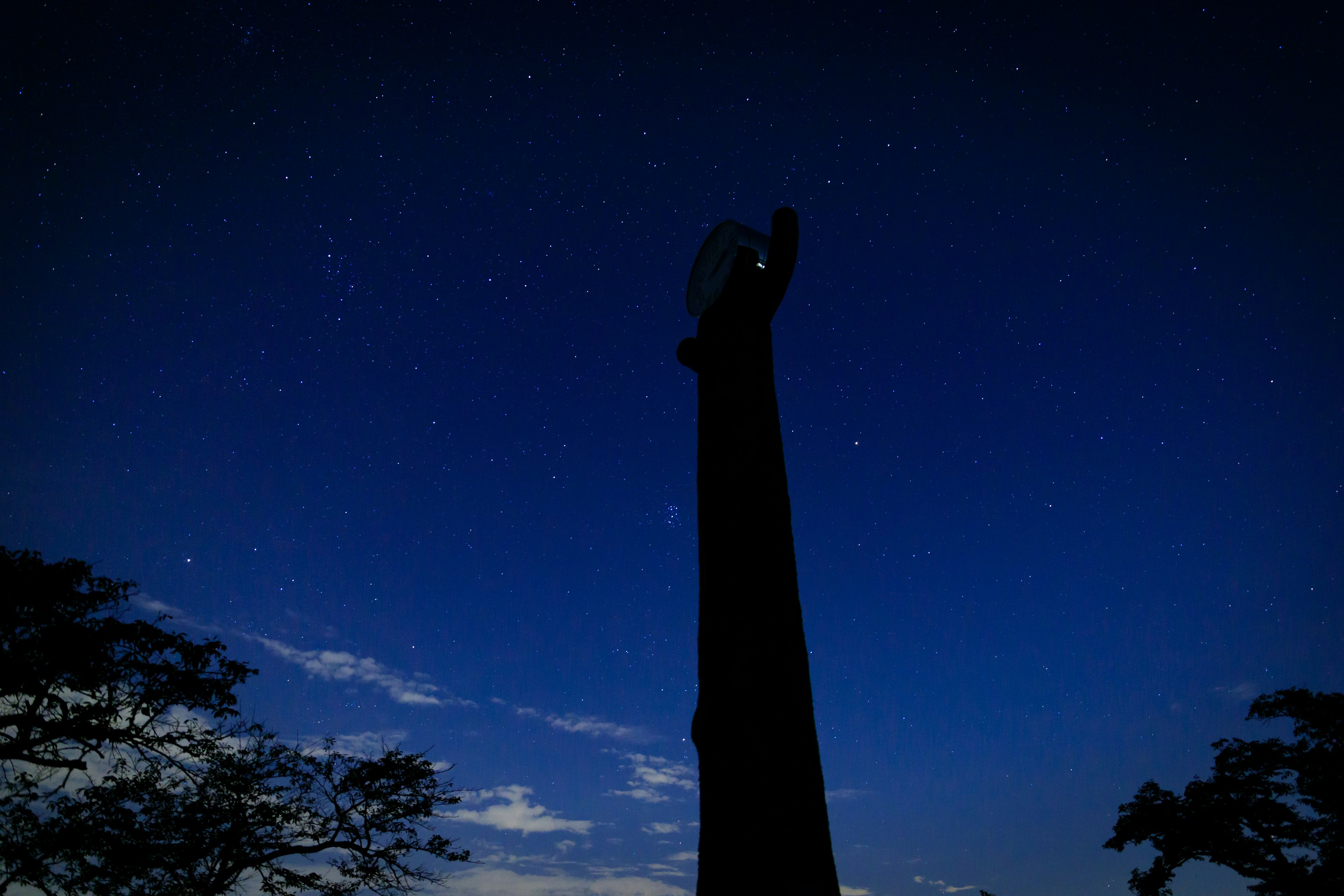 Siluet kolom tinggi melawan langit malam berbintang