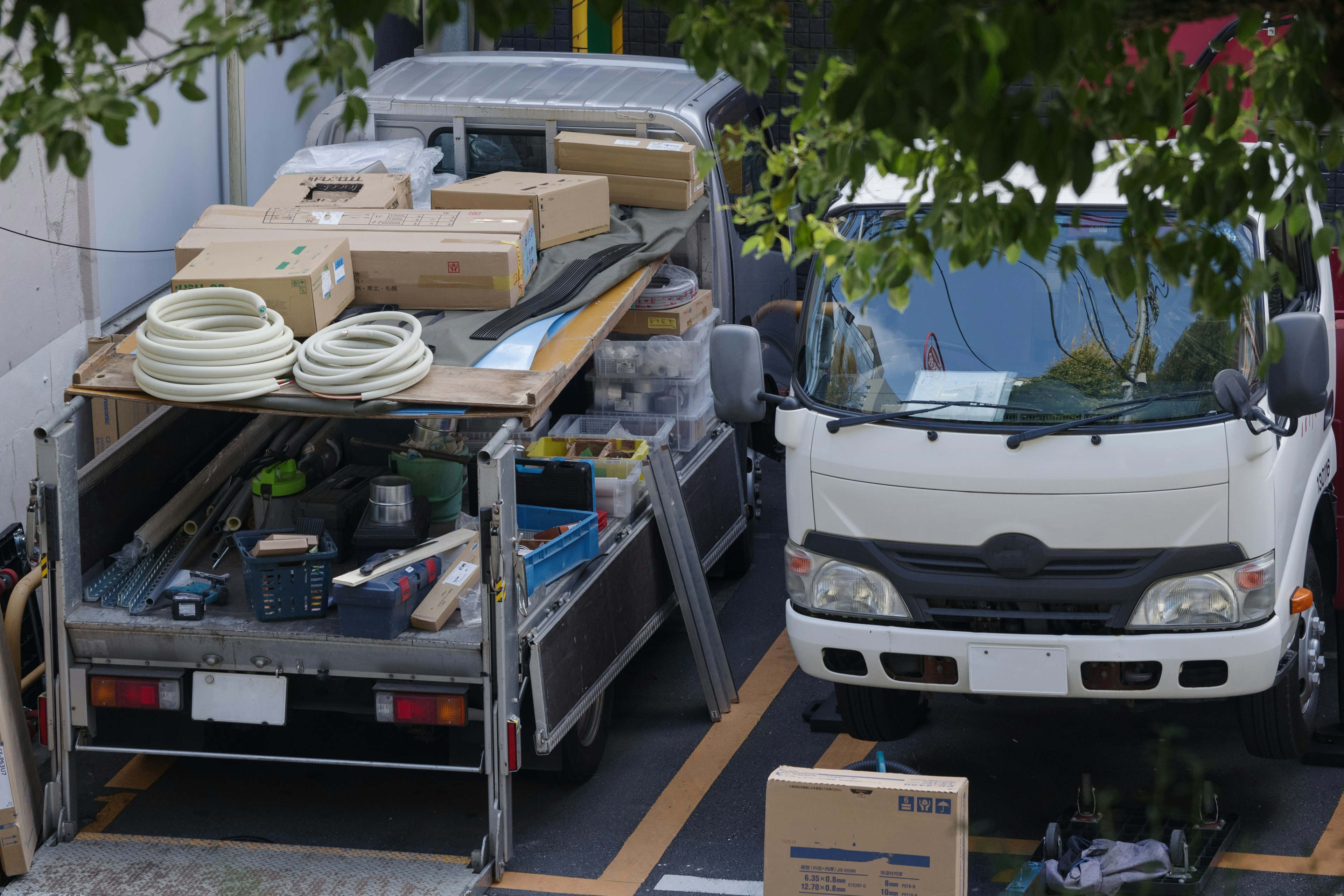 Scène de parking montrant un camion chargé de boîtes et d'outils