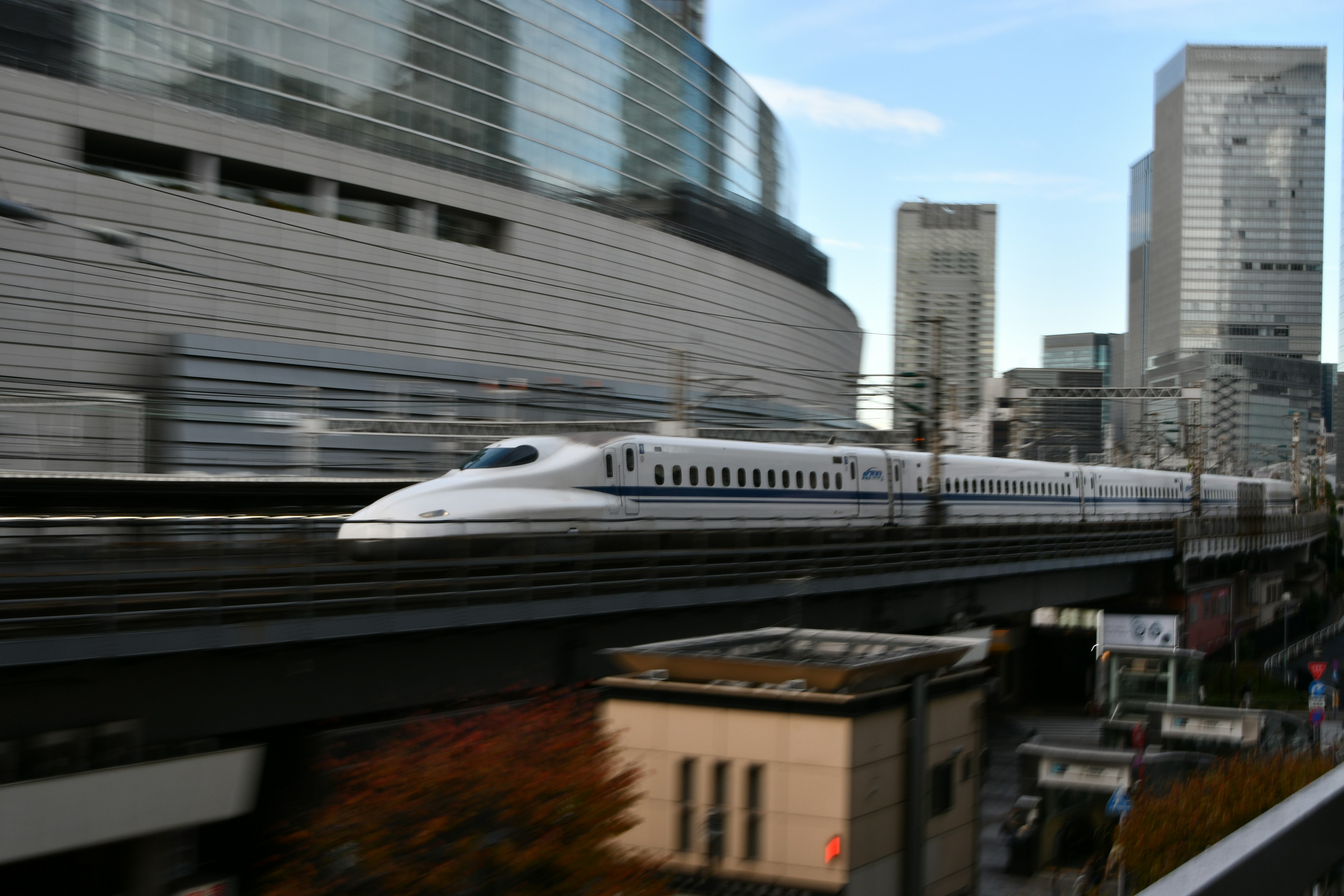 Shinkansen speeding through a cityscape with skyscrapers