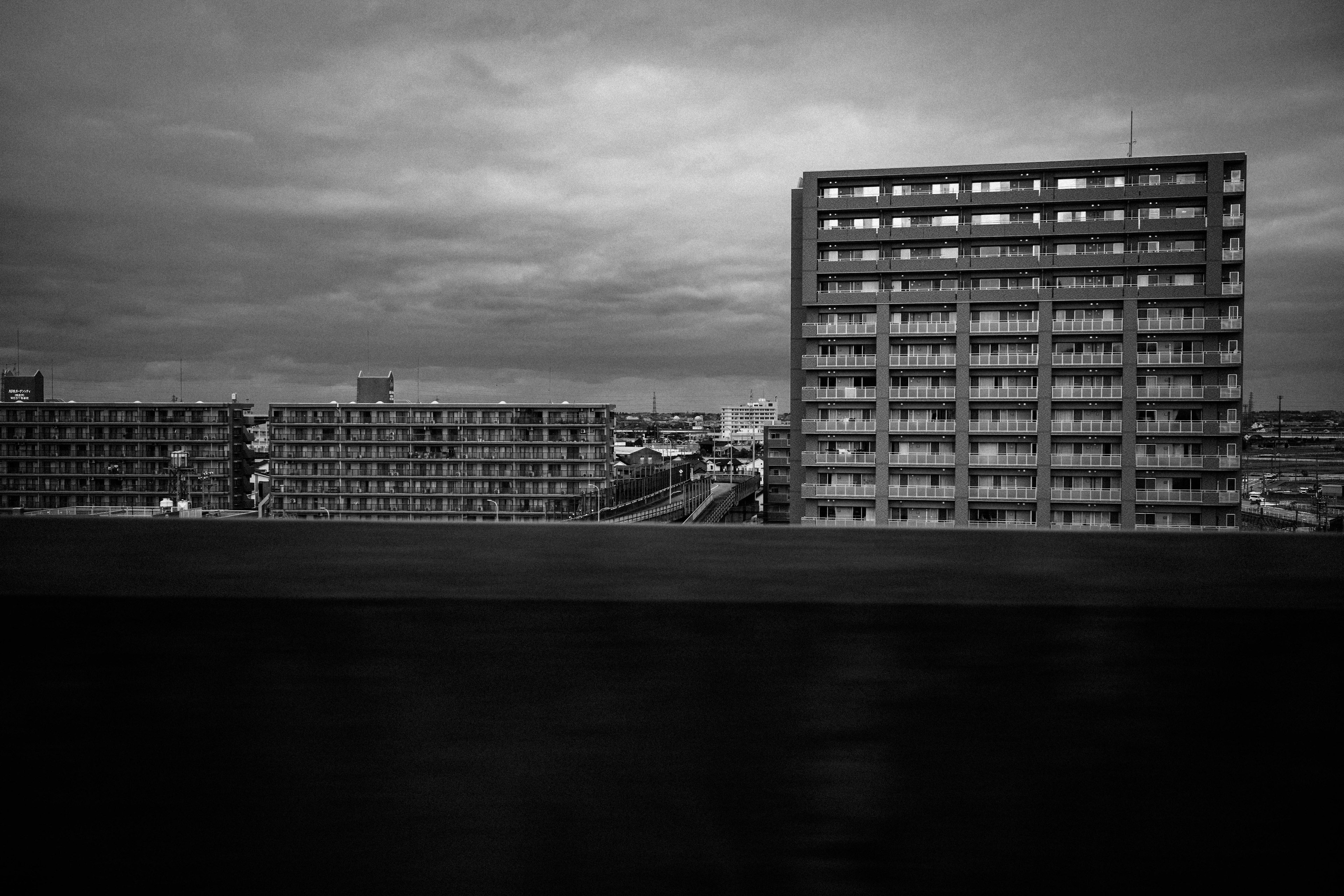 黑白城市風景，包含高樓和陰雲密布的天空