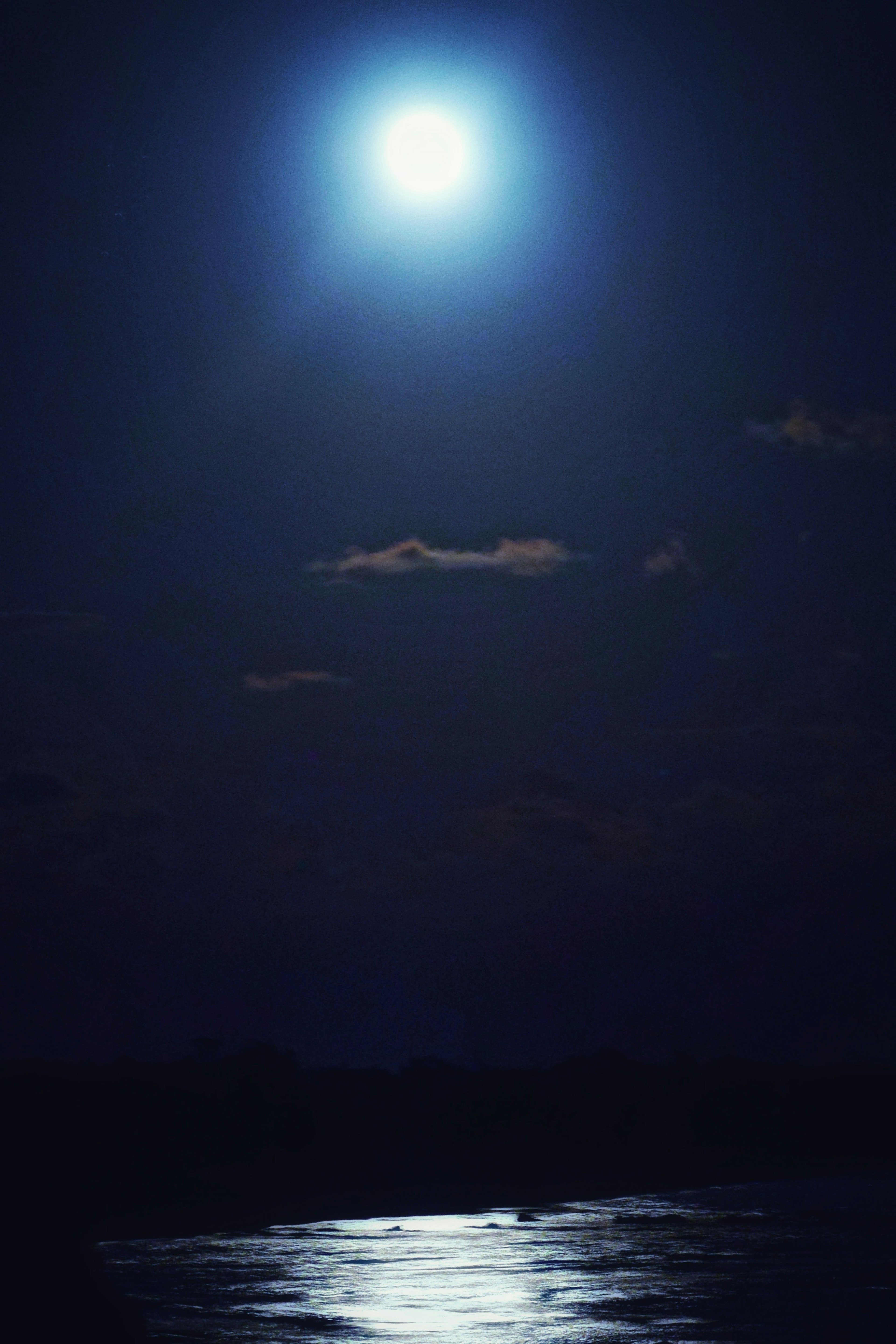 Bulan terang bersinar di langit malam memantul di permukaan air