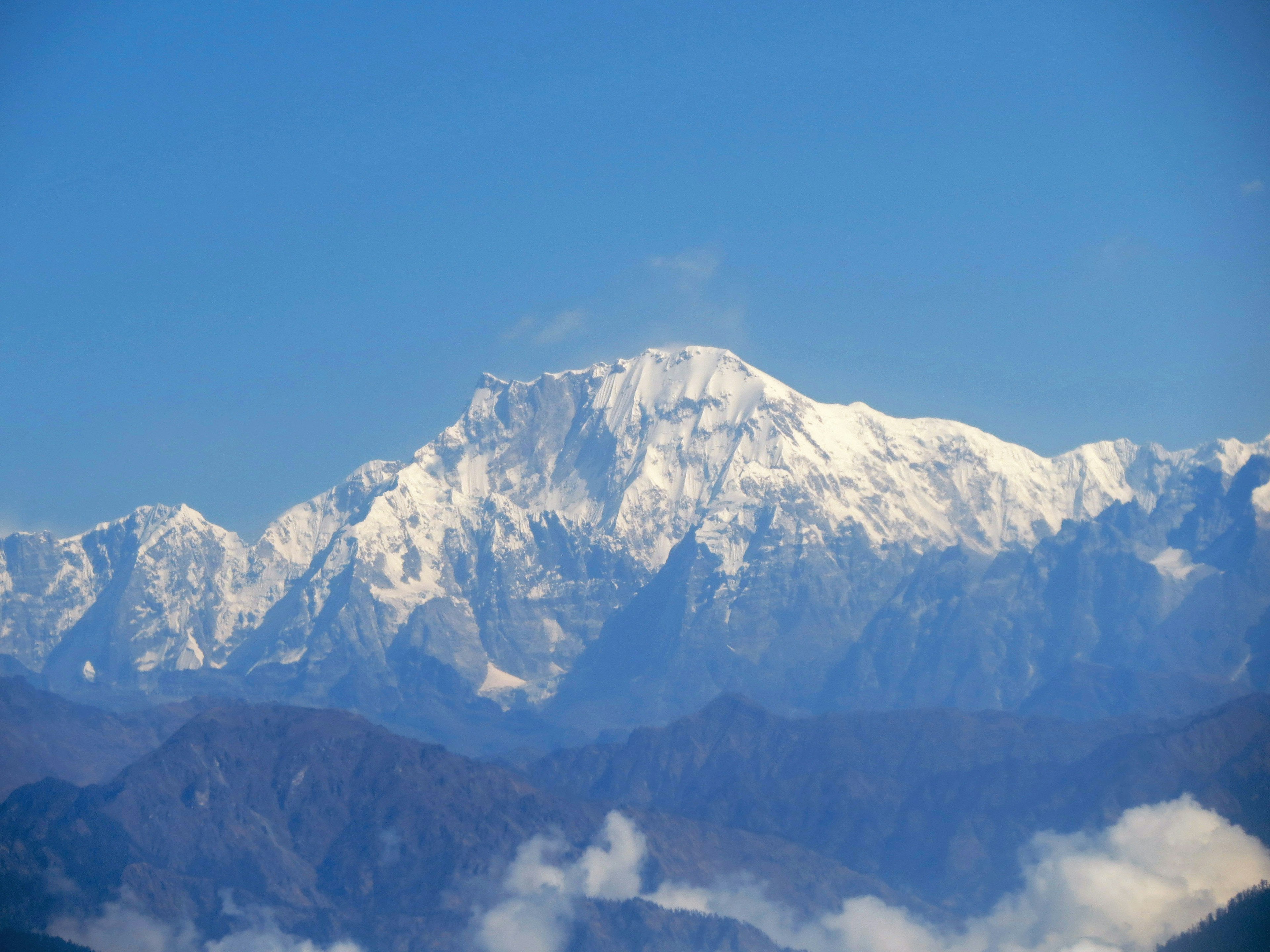 Chaîne de montagnes enneigées sous un ciel bleu clair