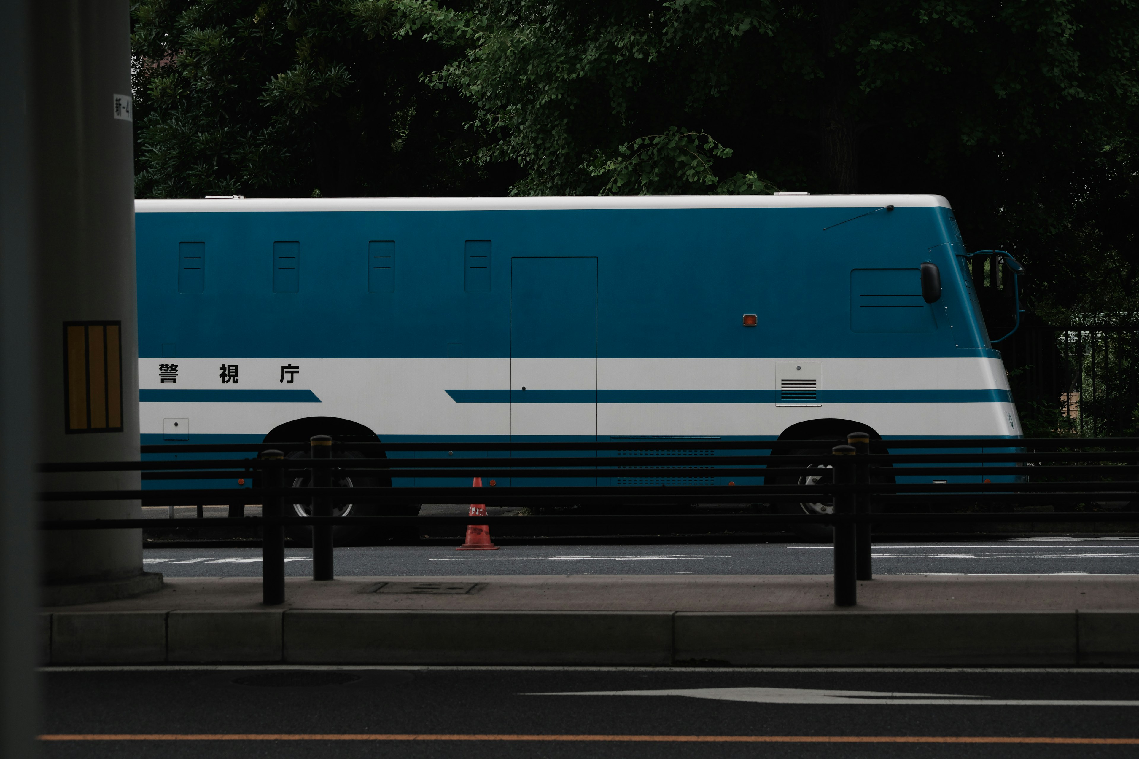 A blue and white bus parked on the side of the road