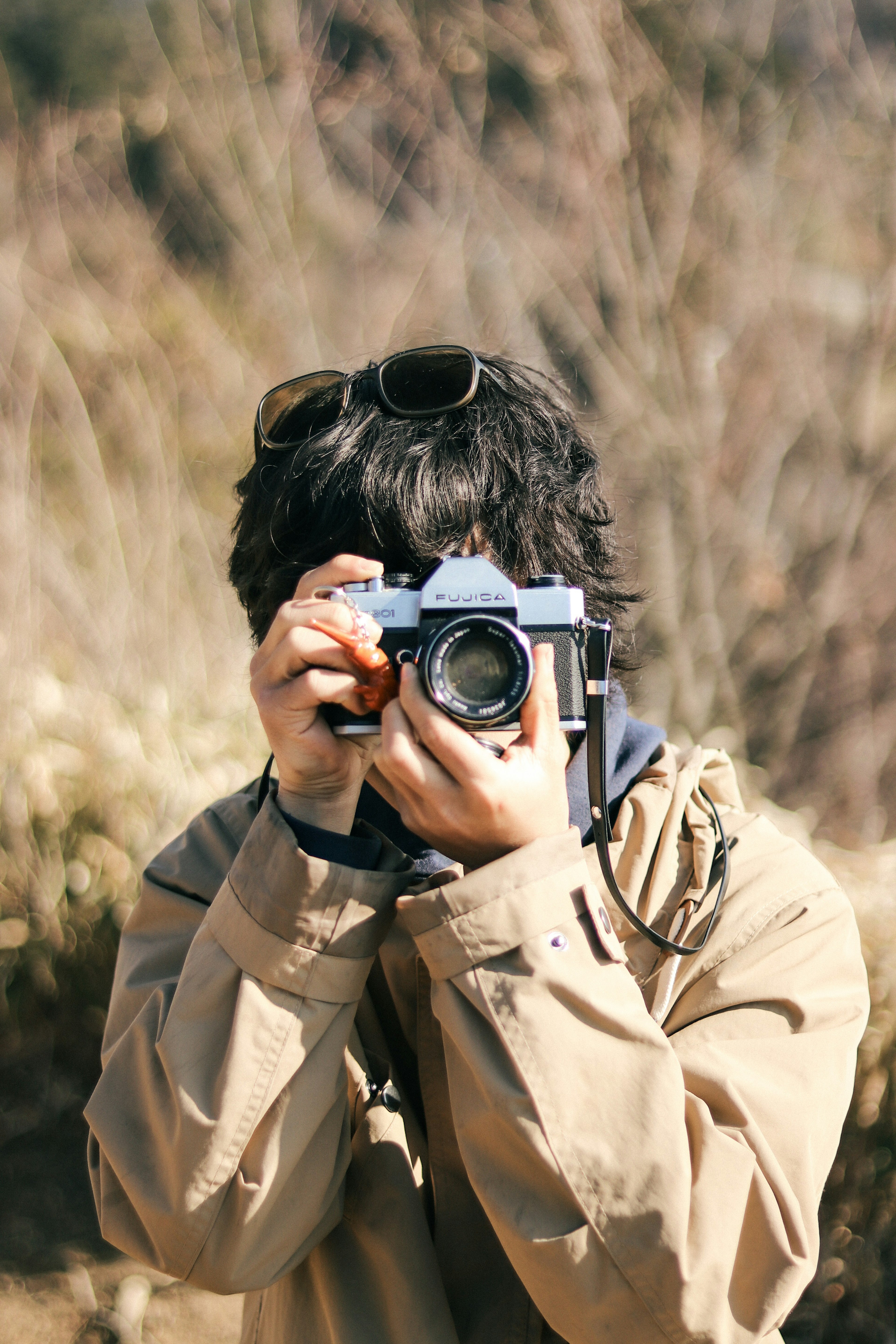 カメラを持っている若い男性のポートレート 自然の中で写真を撮る姿